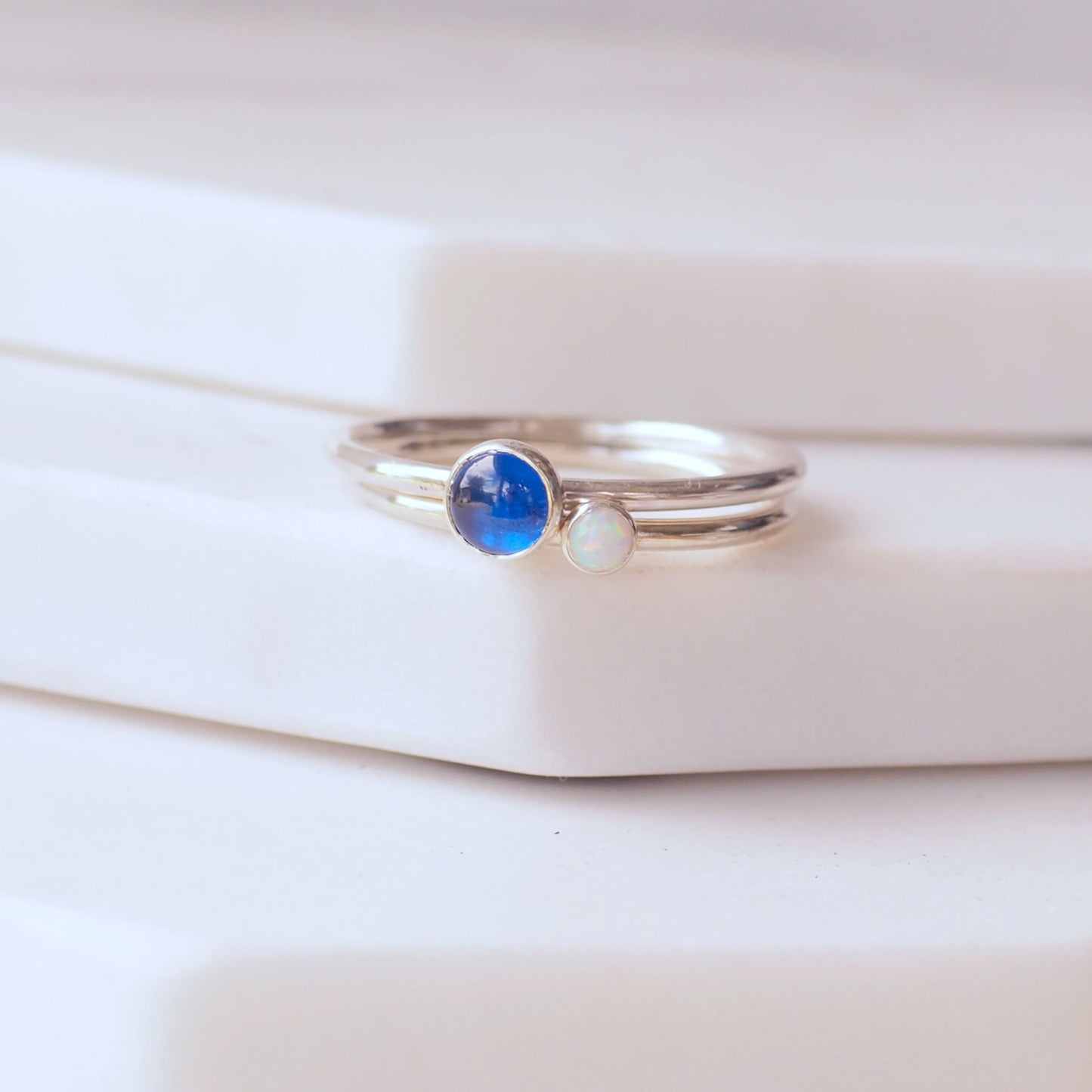 Two ring set with A September and October birthstone - a bright blue lab sapphire and a bright white  Lab Opal . Handmade in Scotland by maram jewellery