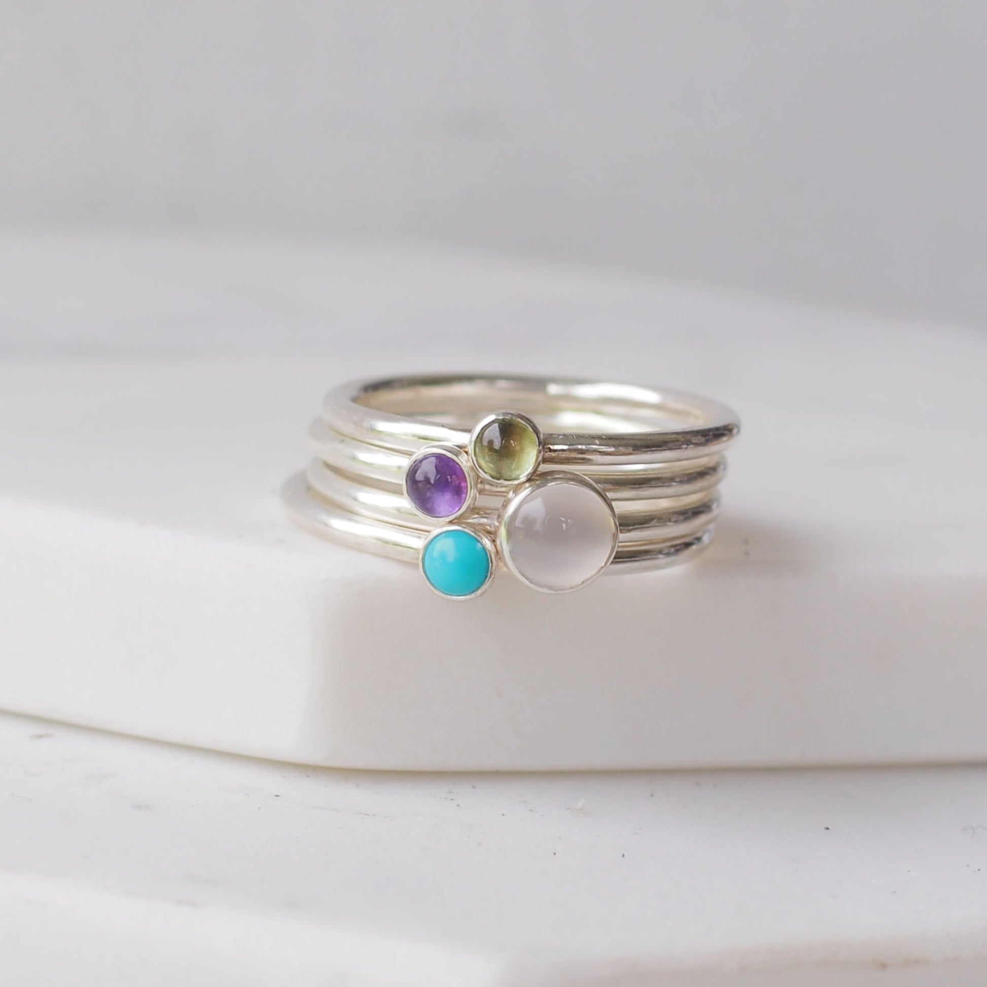 gemstone Birthstone rings in silver, moonstone, turquoise, amethyst and peridot to symbolise June, February, August and December Birthstones. Handmade in Scotland UK by Maram Jewellery
