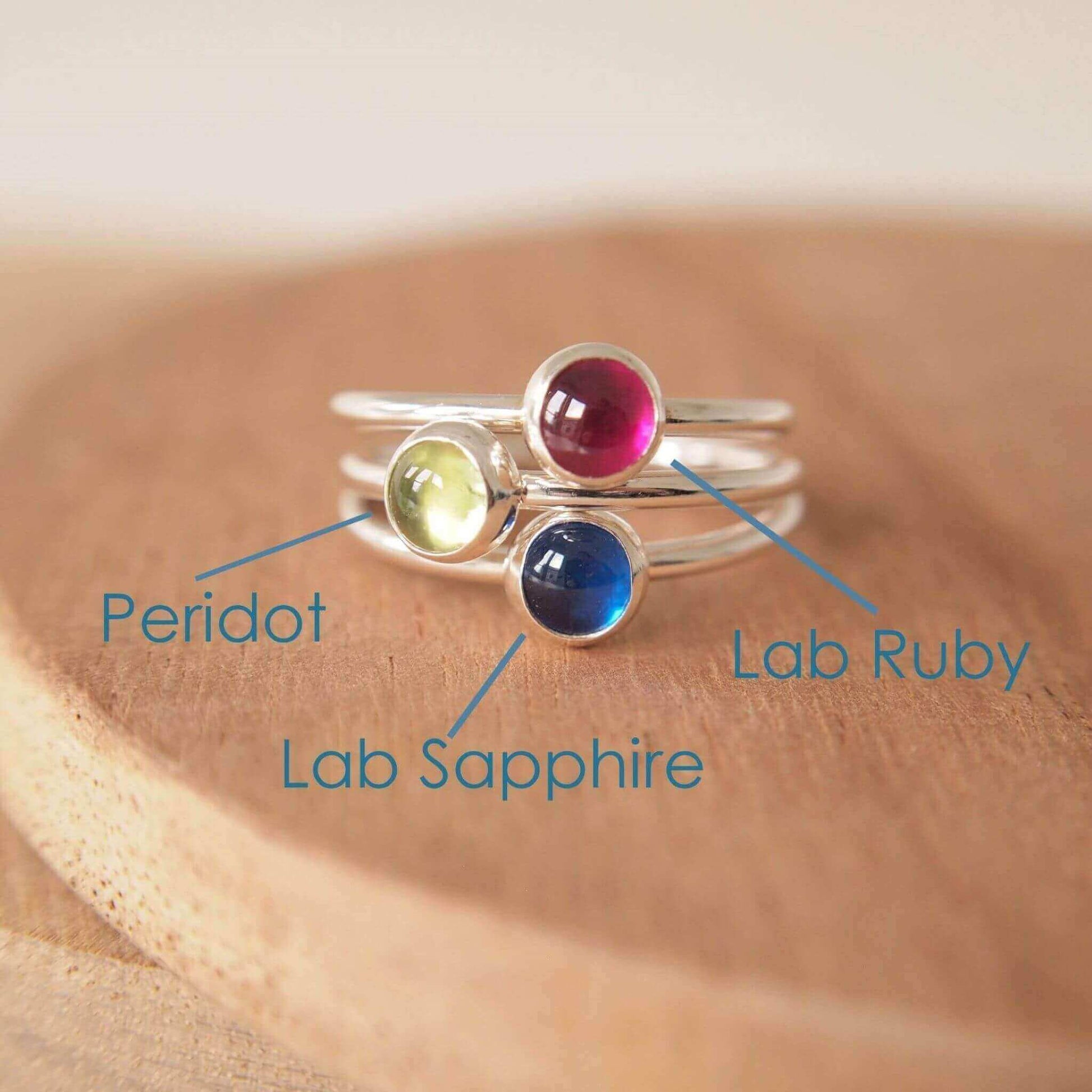 Three Silver rings, each set simply with a single gemstone in Lab Ruby, Peridot and Lab Sapphire in a round 5mm size. Birthstones for July, August and September. Handmade by Maram Jewellery in Edinburgh