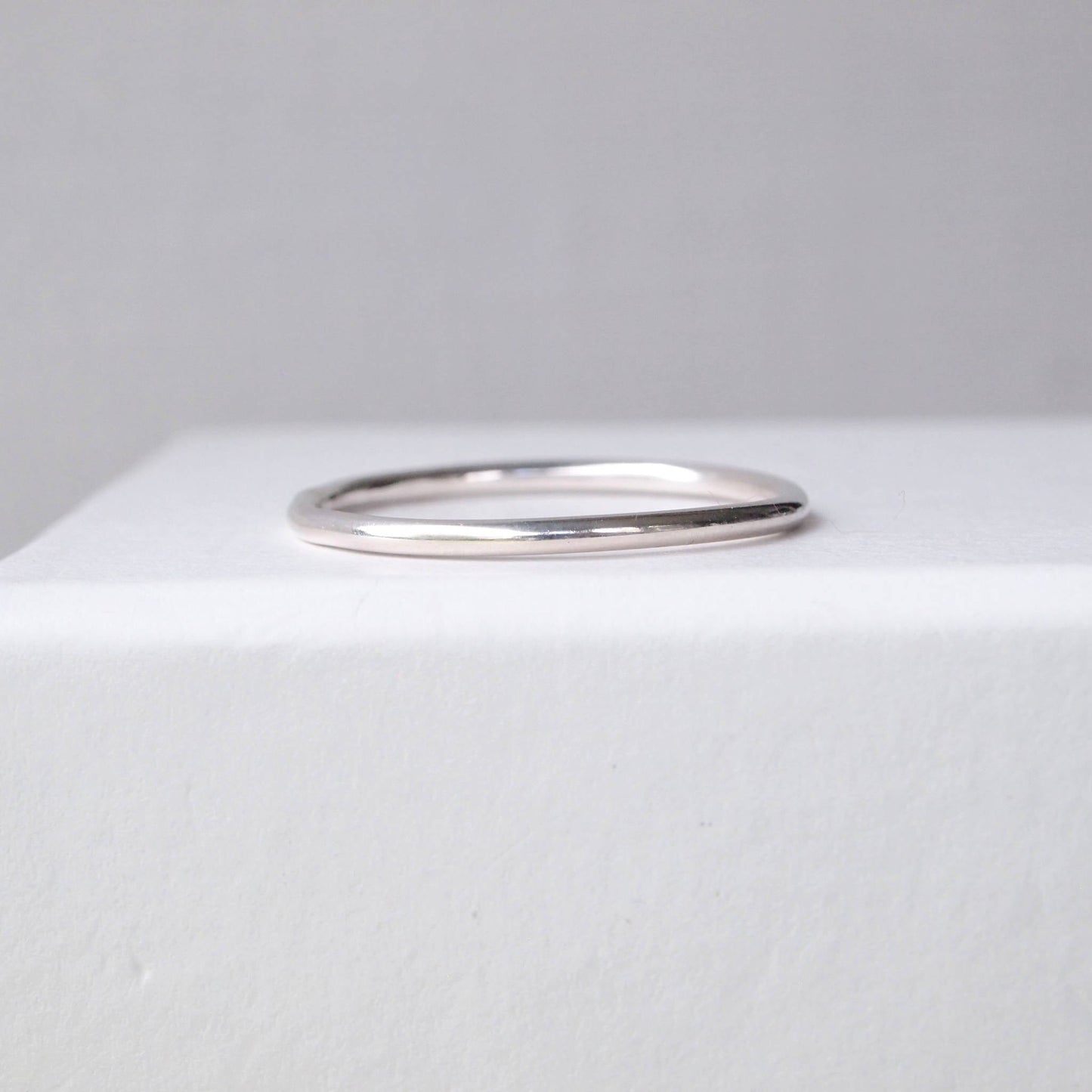 Plain round profile wedding plain band with no details. minimalist sterling Silver ring pictured on a white background. Handmade to your ring size by maram jewellery in Edinburgh UK