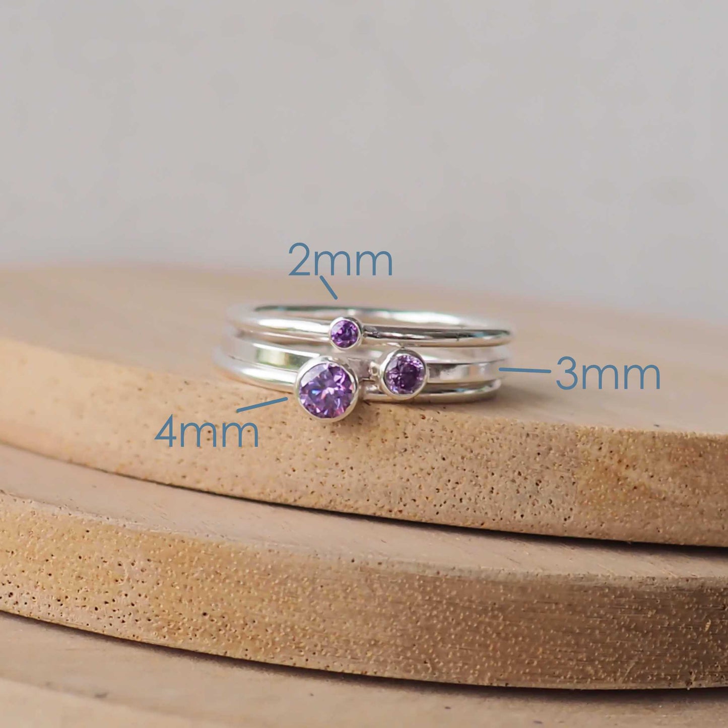 Three rings showing the square and round band styles with three different sized Cubic Zirconia in a deep purple Amethyst. The rings are made from Sterling Silver and a round purple cubic zirconia measuring 2,3 or 4mm in size. Handmade by maram jewellery in Scotland