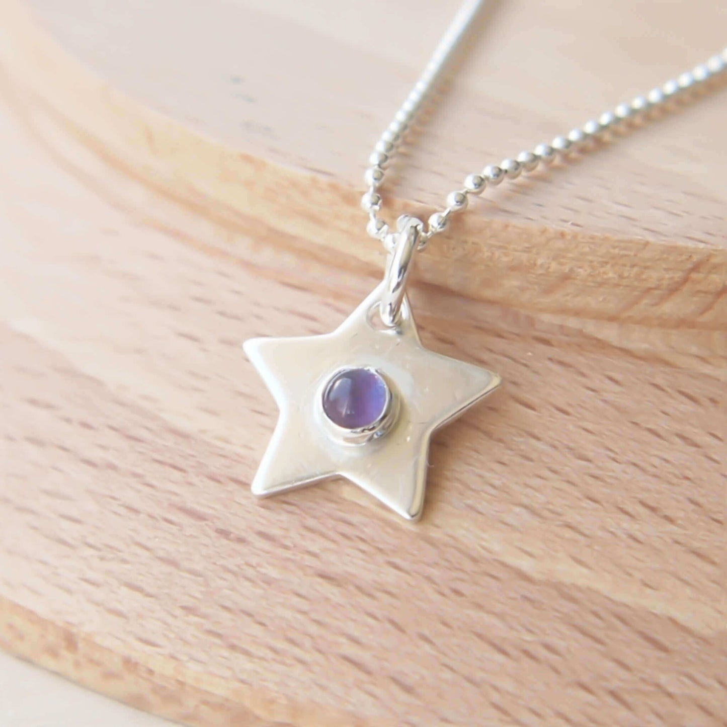 Simple silver star pendant with February Birthstone Amethyst which is a purple gemstone. The pendant is made from Sterling Silver and is handmade by maram jewellery in Scotland UK