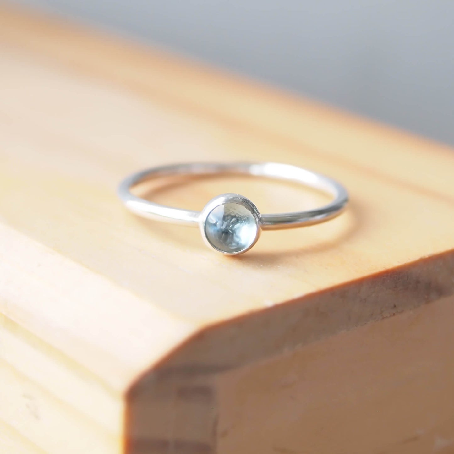 Aquamarine and Sterling Silver solitaire gemstone ring with a round 5mm clear aquamarine set very simply on a round silver band to create a minimalist style ring. Handmade by maram jewellery in Scotland