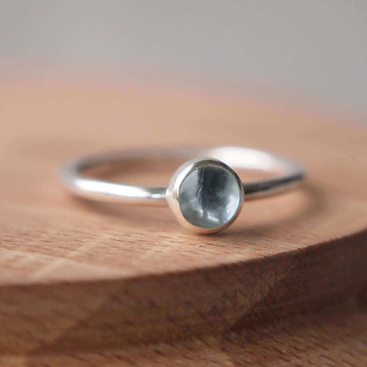 Aquamarine and Sterling Silver solitaire gemstone ring with a round 5mm clear aquamarine set very simply on a round silver band to create a minimalist style ring. Handmade by maram jewellery in Scotland