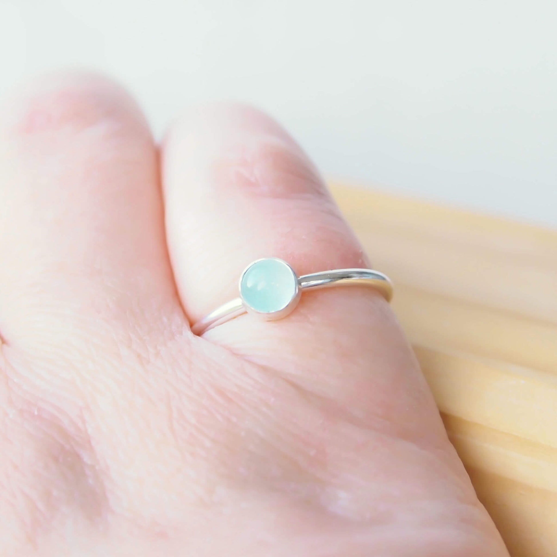 Cloudy Aquamarine birthstone ring for March. A 5mm round pale blue cabochon set simply onto a simple round band. The ring is made to measure to your size by maram jewellery in Scotland