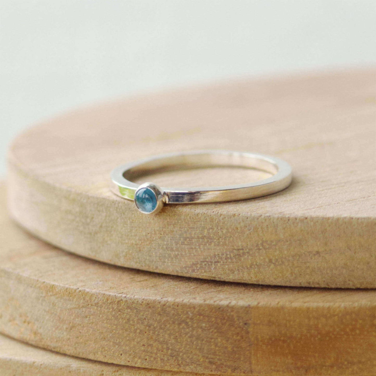 Small gemstone ring in sterling silver with a modern square band with a 3mm sized round light blue Aquamarine. Handmade in Edinburgh by Maram Jewellery