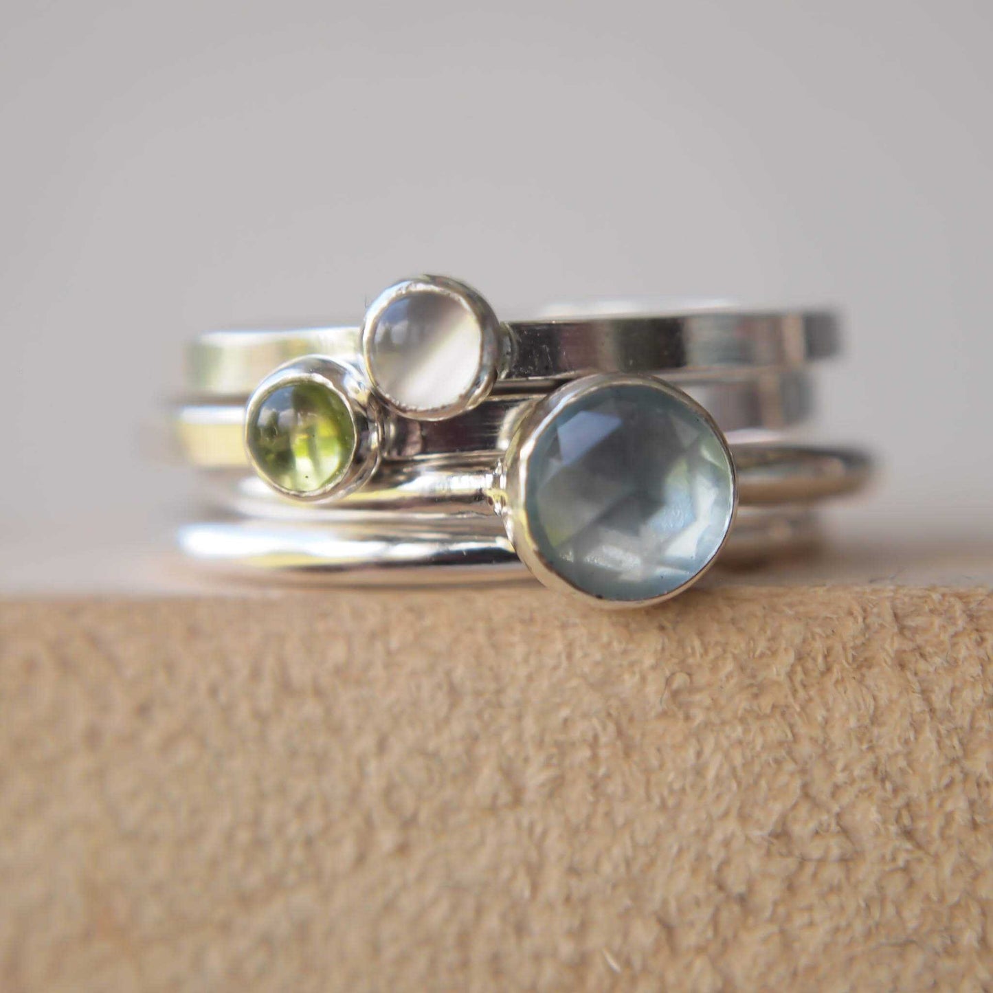 Stacking ring set with aquamarine, moonstone, and peridot. all in different sized round stones. The  gemstones colours are aqua, moss green and milky white on silver. Handmade in Scotland by maram jewellery