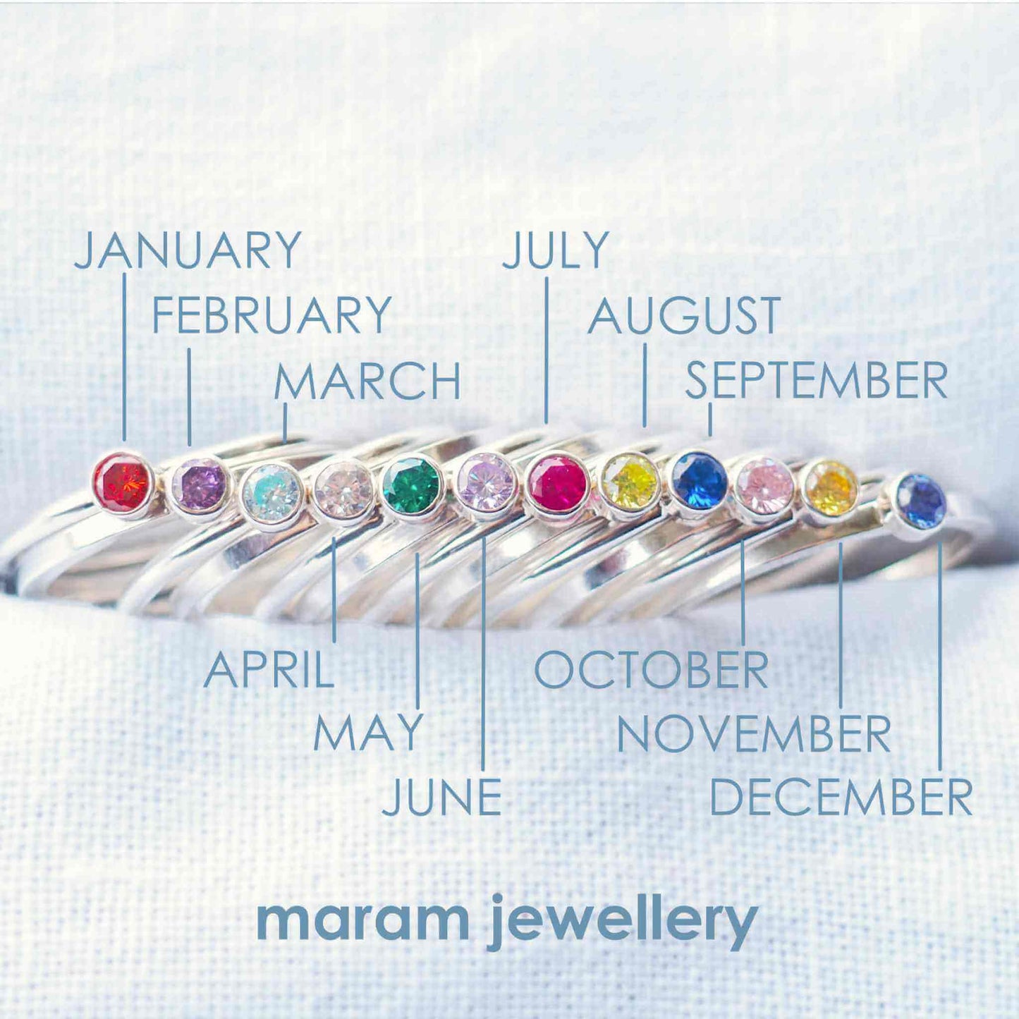 Infographic to show birthstone colours for maram jewellery's range of cubic zirconia rings. the rings are simple styled with plain bands and 4mm round facet cut gemstones in bright colours. Handmade in Scotland by a small business jewellery