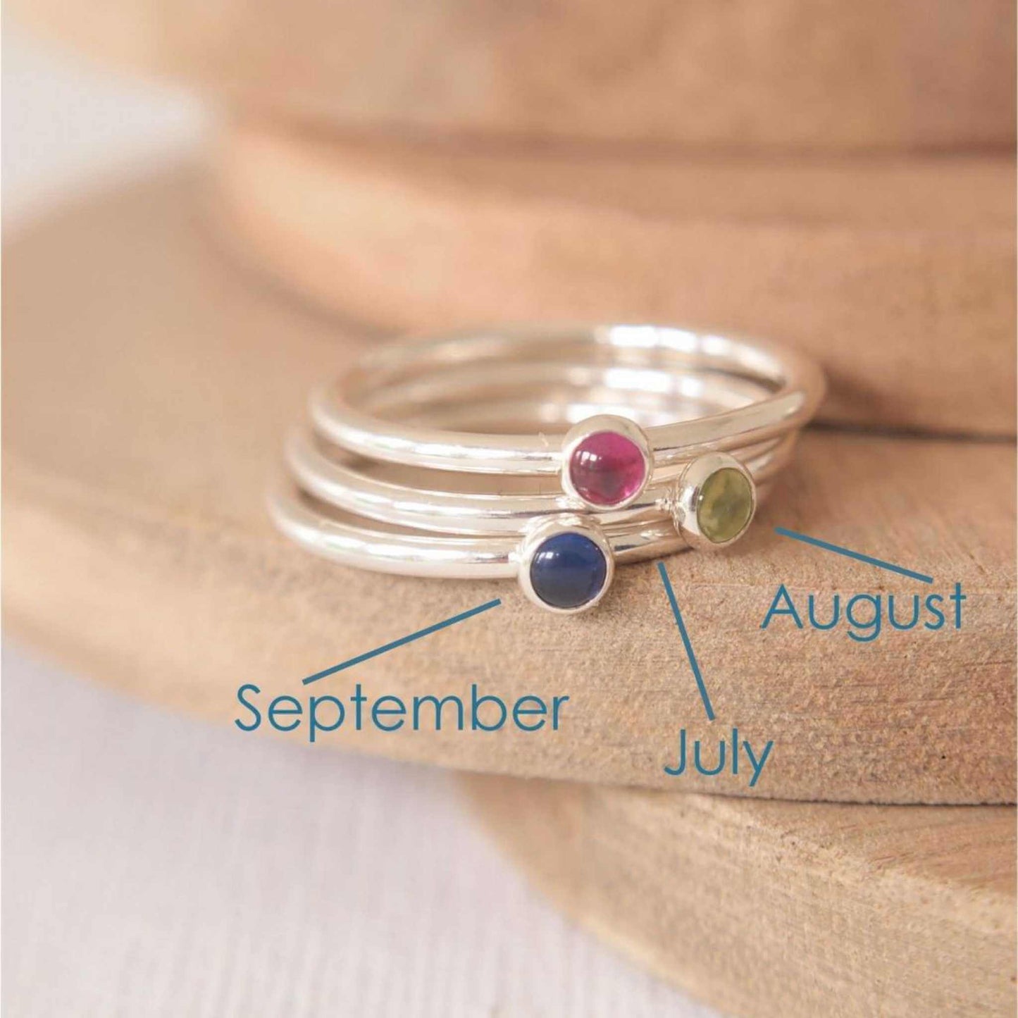 Three Silver rings, each set simply with a single gemstone in Lab Ruby, Peridot and Lab Sapphire in a round 3mm size. Birthstones for July, August and September