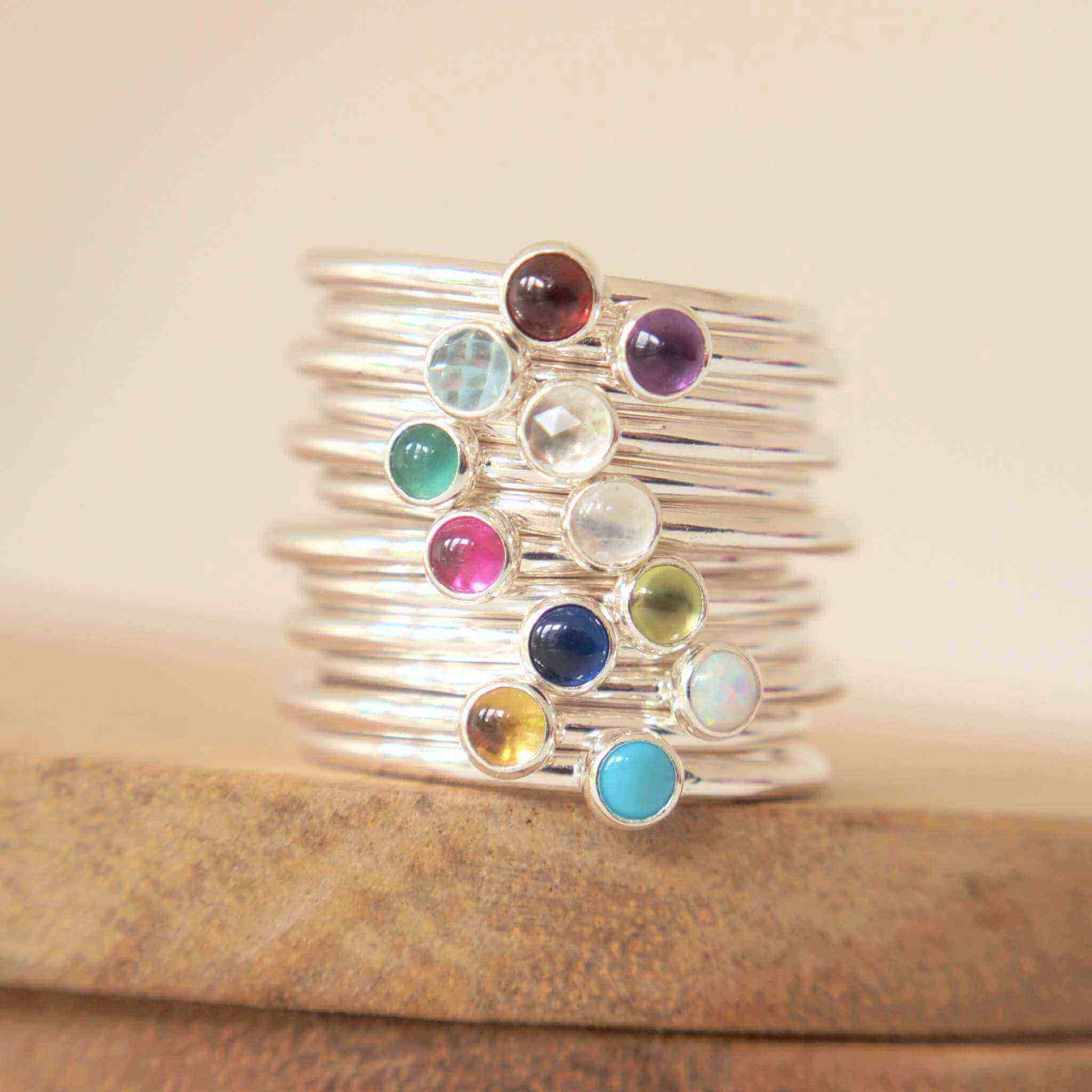 Set of twelve sterling silver gemstones rings each with a small 3mm round cabochon. Each ring has a birthstone from January to December . Handmade by Maram Jewellery in Edinburgh