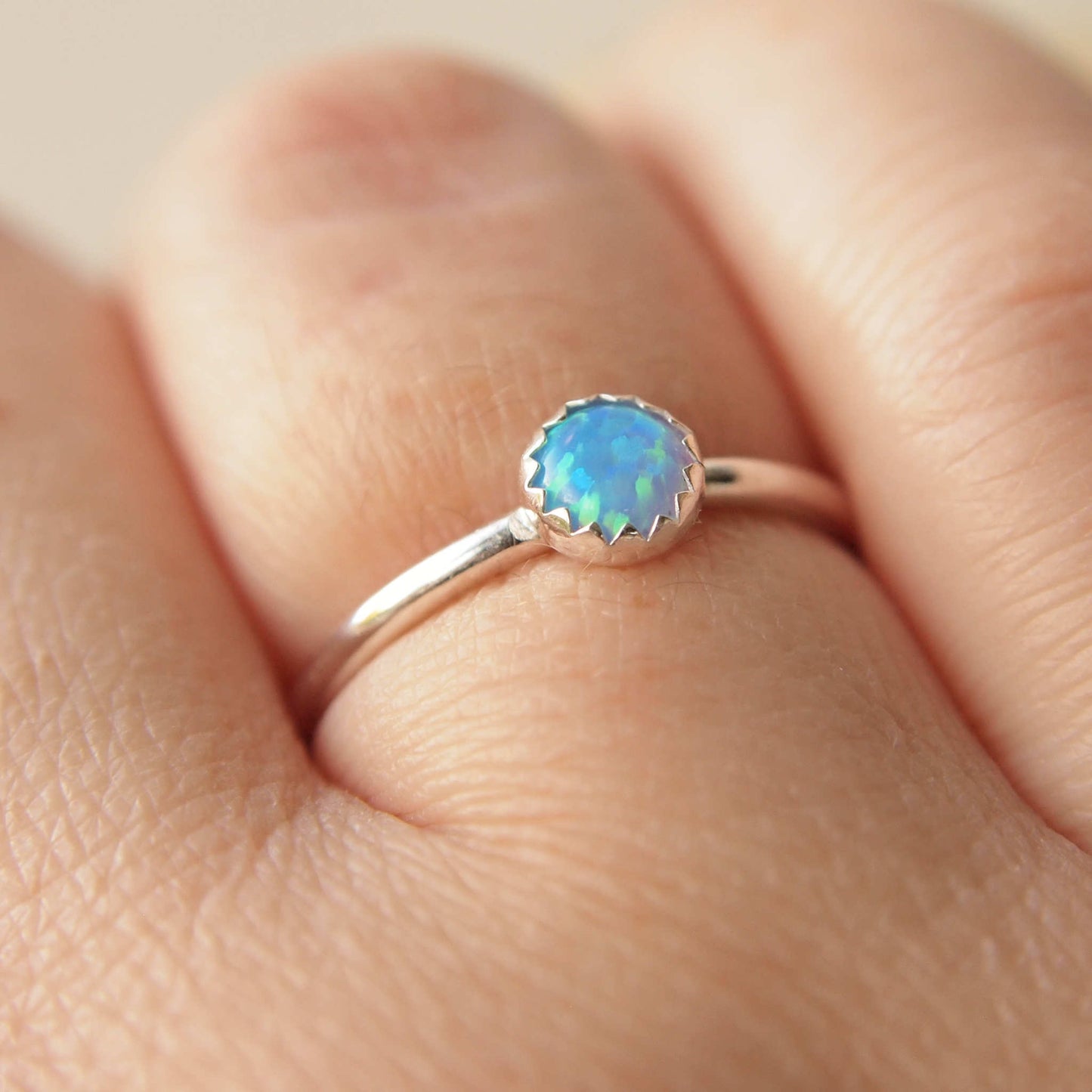 Simple style Lab Opal and Sterling Silver single Solitaire Ring with Lab Opal. Opal is Birthstone for October. The round 5mm gem is a blue opal with lots of iridescence. Handmade by Maram Jewellery in Scotland