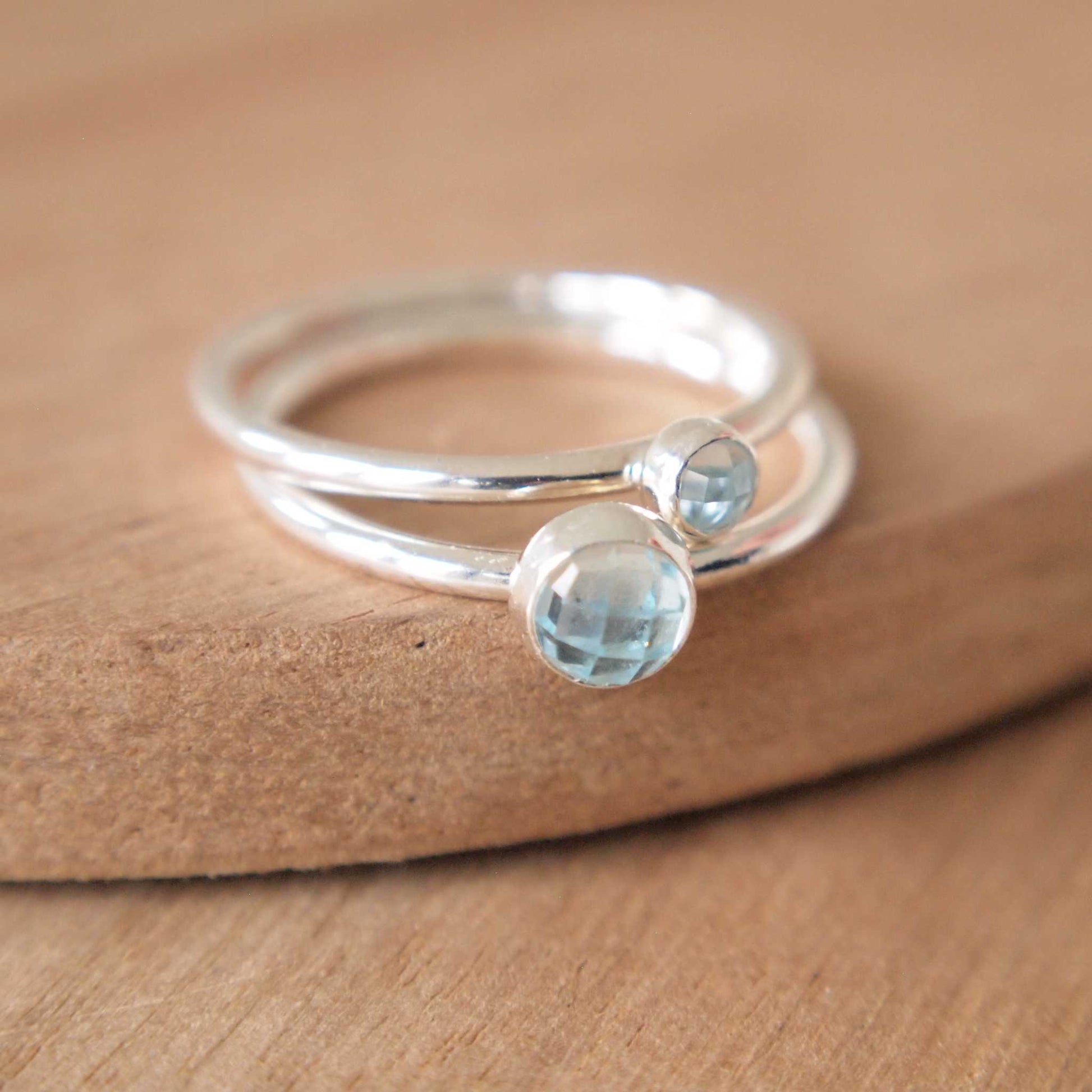 Two ring set in Sterling Silver and Blue Topaz. The rings have two round facet cut cabochons in 5mm and 3mm size in a pale blue colour, and are set very simply onto bands of Sterling Silver. Handmade in Scotland by Maram Jewellery