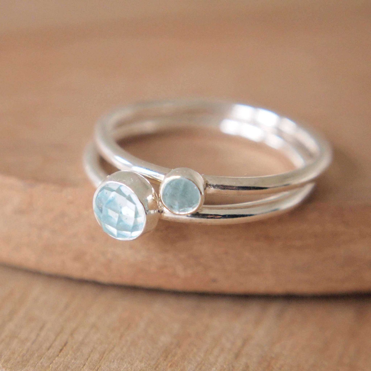 Two ring set in Sterling Silver and Blue Topaz. The rings have two round facet cut cabochons in 5mm and 3mm size in a pale blue colour, and are set very simply onto bands of Sterling Silver. Handmade in Scotland by Maram Jewellery