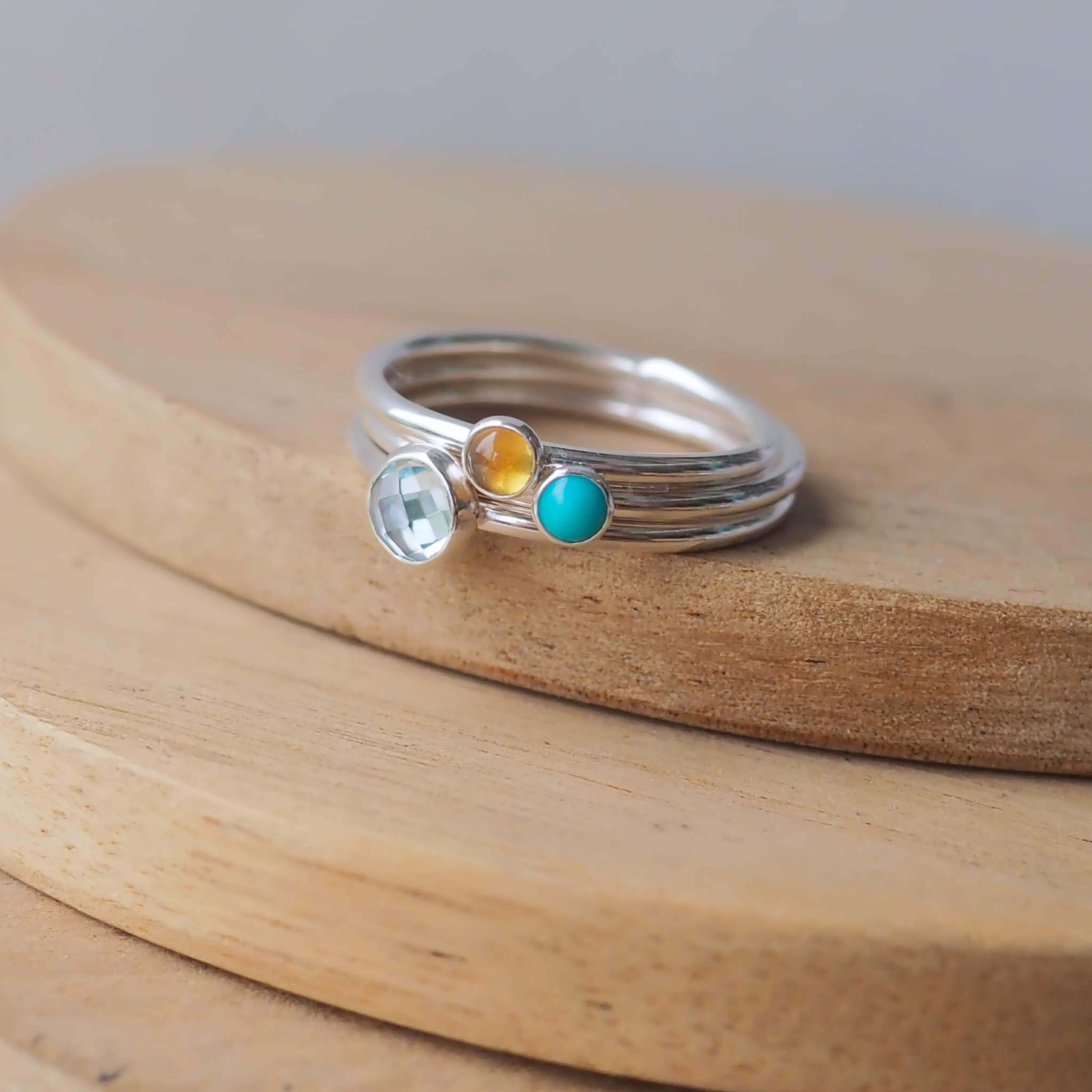 Three Birthstone RIng set with Blue Topaz, Citrine and Turquoise to mark March, November and December Birthdays. The three rings are made with Sterling Silver and a 5mm blue round cabochon, with two further rings with 3mm round gems in a Turquoise and yellow citrine. Handmade in Scotland by maram jewellery
