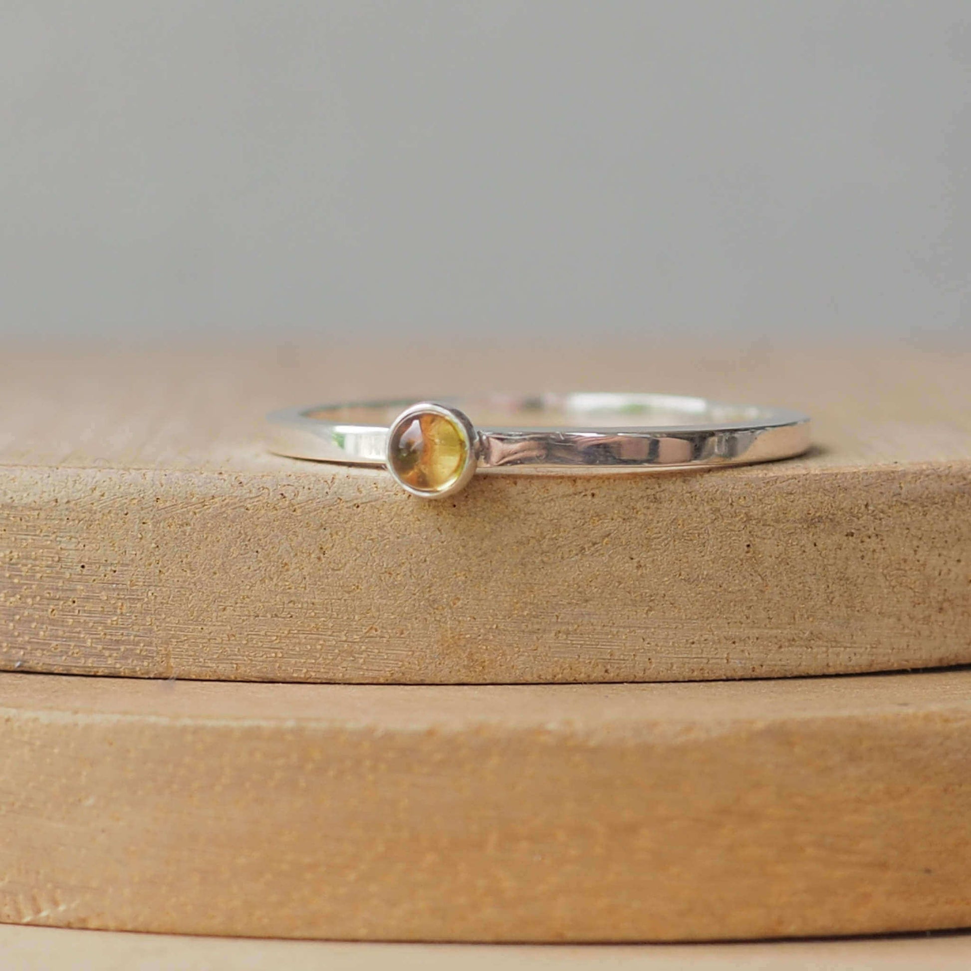 Citrine and Sterling Silver Ring made from a small 3mm round warm yellow citrine gemstone set simply onto a modern band of square wire. Handmade to your ring size by maram jewellery in Scotland