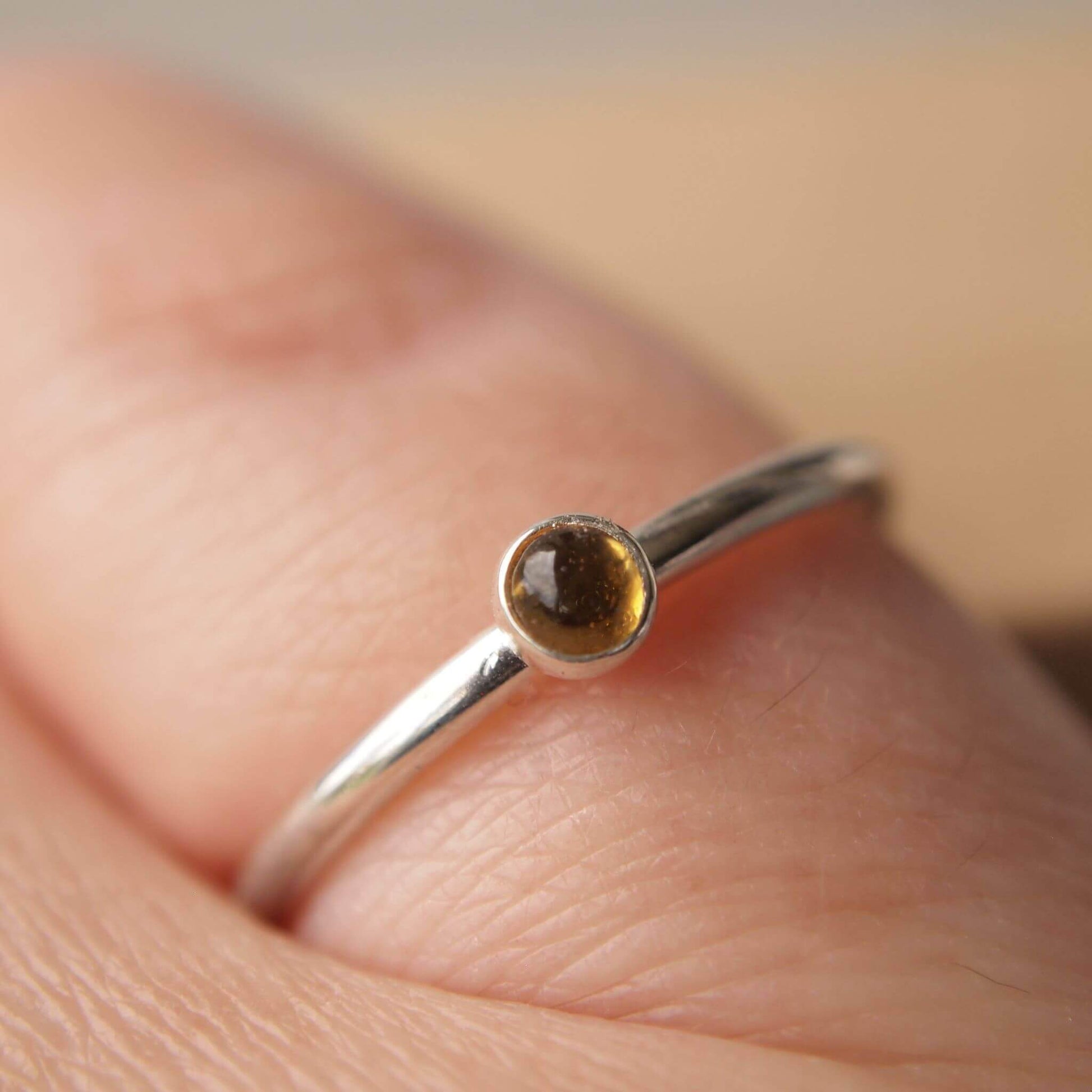 Citrine and Sterling Silver Ring made from a small 3mm round warm yellow citrine gemstone set simply onto a modern band of fully round wire. Handmade to your ring size by maram jewellery in Scotland
