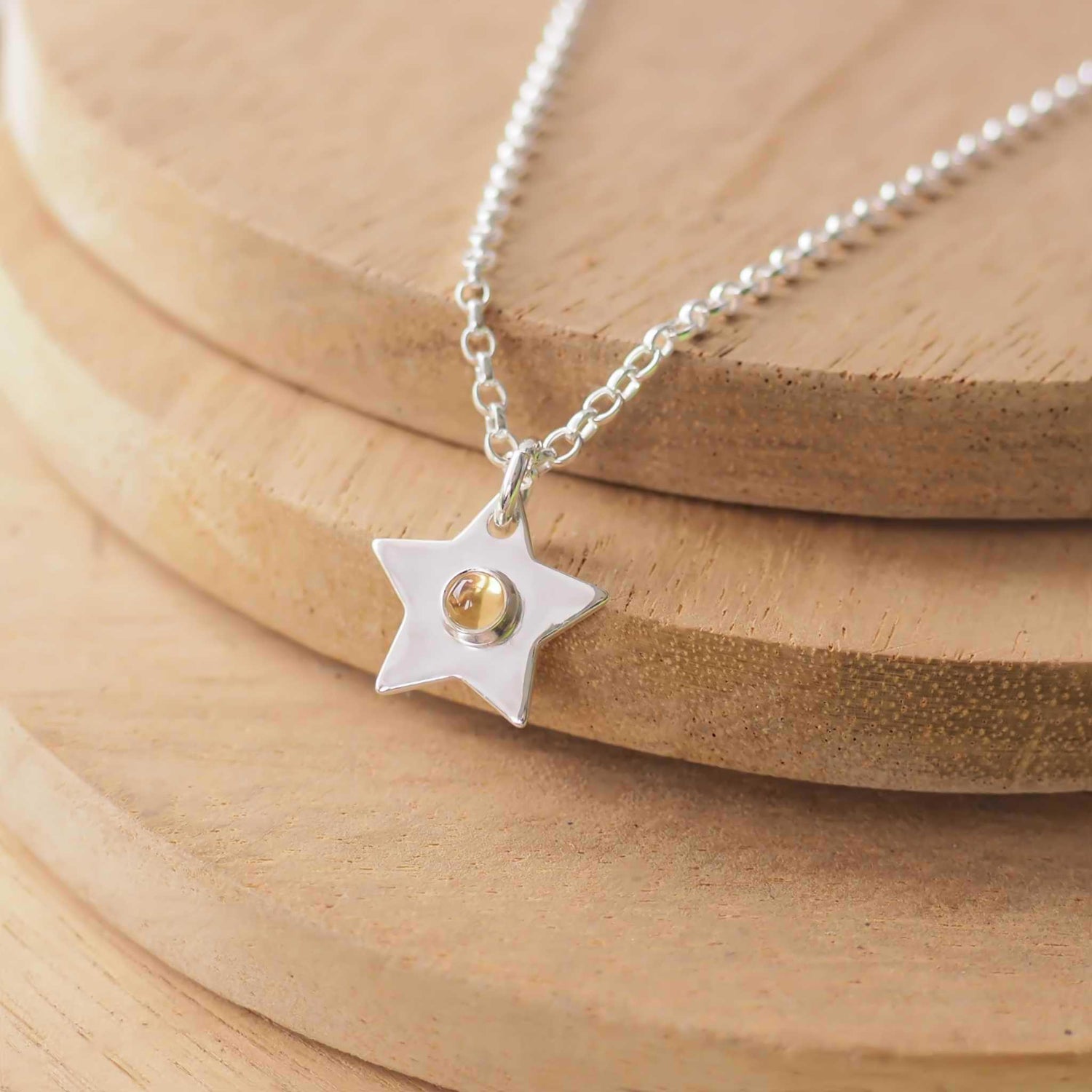 November Birthstone Charm Necklace in the shape of a star with a round 3mm citrine cabochon centre. The star measures 12mm in size so is small enough for children as well as adults and is available in a range of other birthstones too. It is Sterling Silver and comes with a choice of chain design and length. Handmade in Scotland by Maram Jewellery