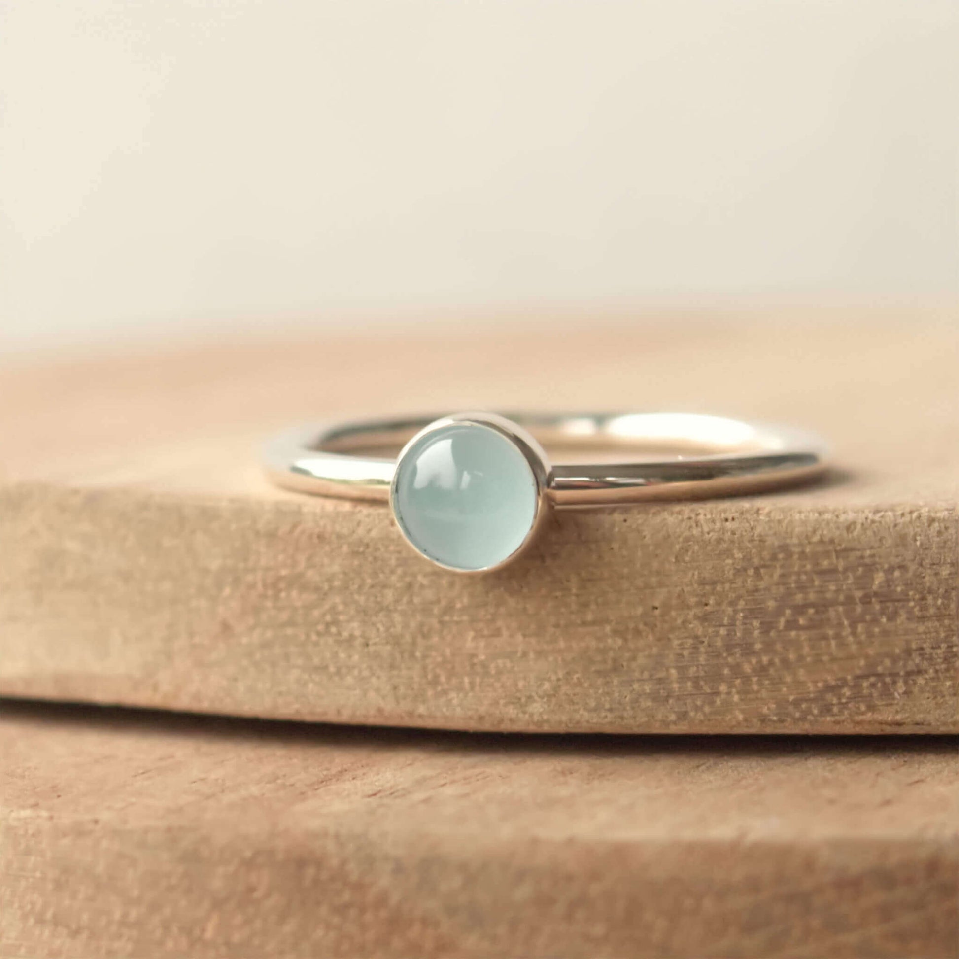Cloudy Aquamarine birthstone ring for March. A 5mm round pale blue cabochon set simply onto a simple round band. The ring is made to measure to your size by maram jewellery in Scotland