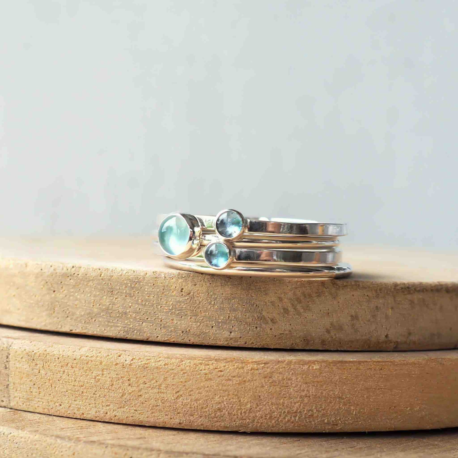 three rings set with different sizes of aquamarine cabochons set onto bands of sterling silver. Handmade in Scotland by maram jewellery