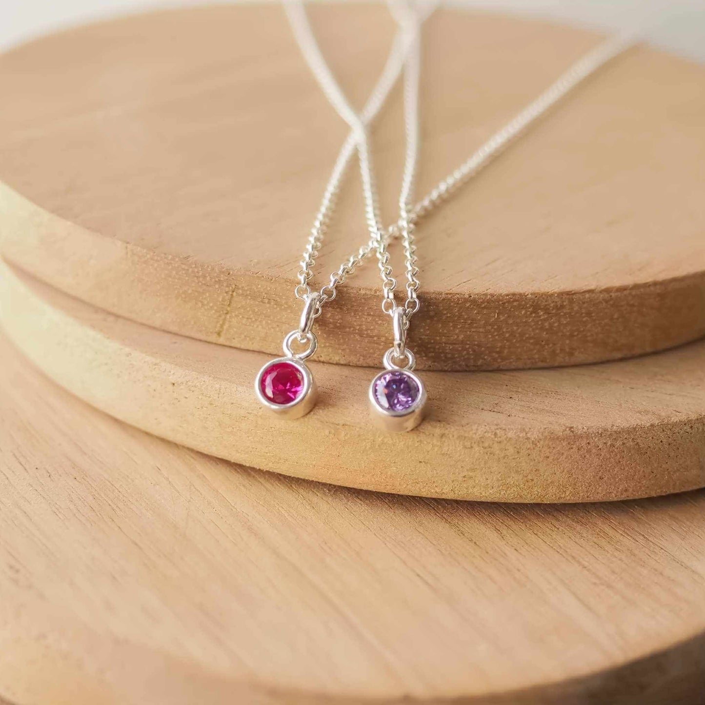 Two Sterling Silver and Cubic Zirconia necklaces in red and purple. Small 4mm facet round gemstones with a simple silver setting on a trace style chain. Handmade in Scotland by Maram Jewellery