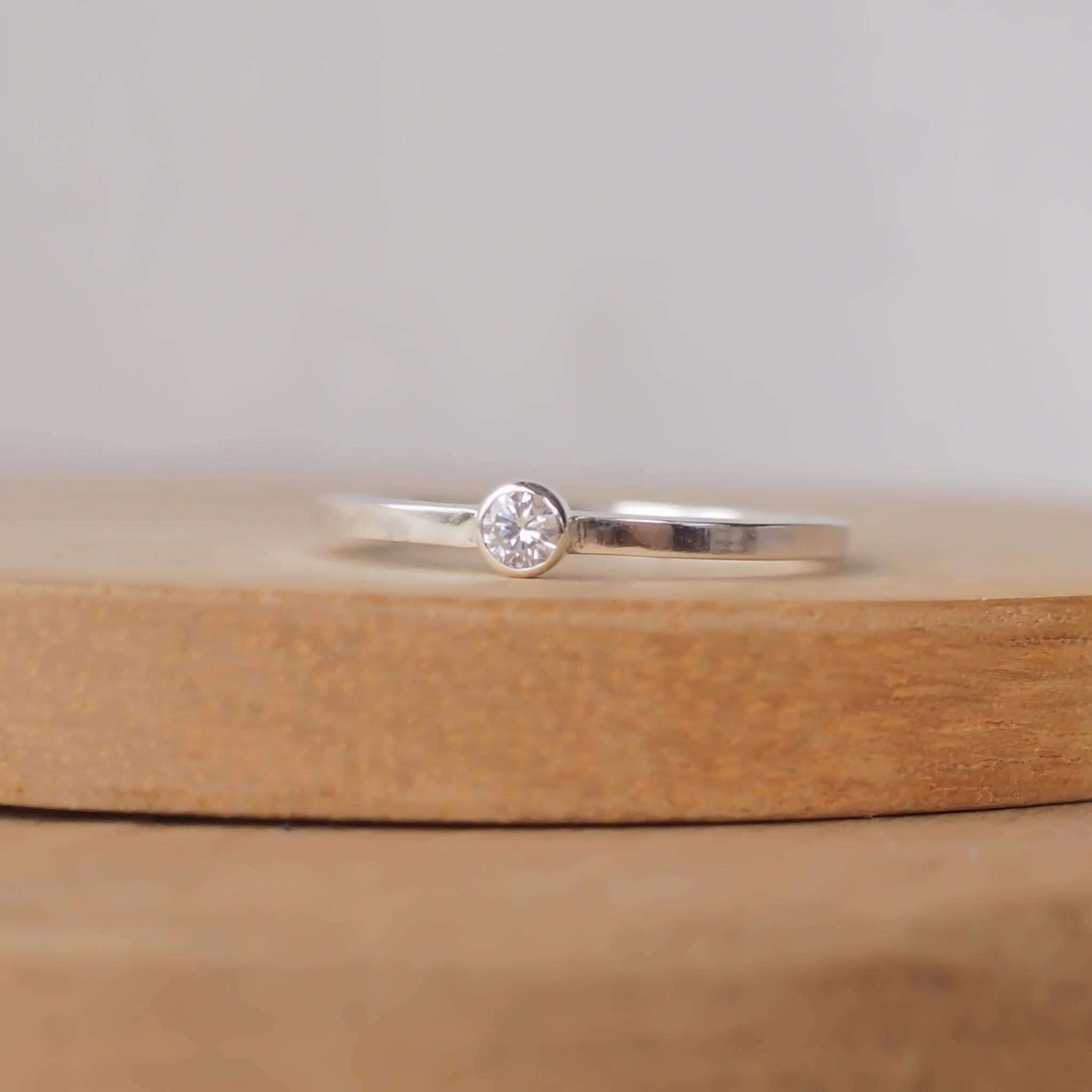 Imitation Diamond and silver minimalist solitaire ring. Made from a modern band of square silver wire with a simple round faceted cubic zirconia. Handmade in Scotland by Maram Jewellery