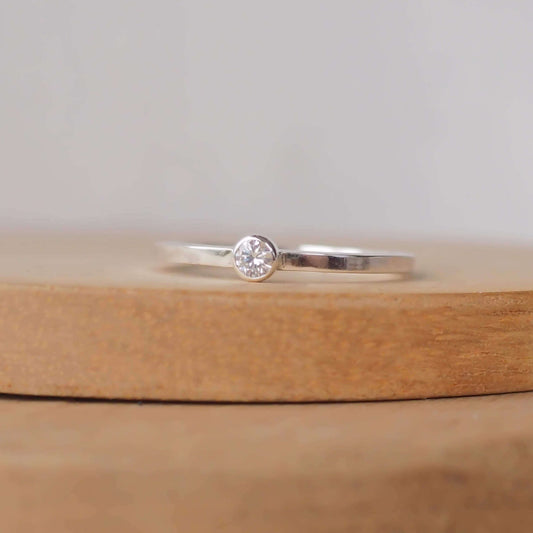 Imitation Diamond and silver minimalist solitaire ring. Made from a modern band of square silver wire with a simple round faceted cubic zirconia. Handmade in Scotland by Maram Jewellery