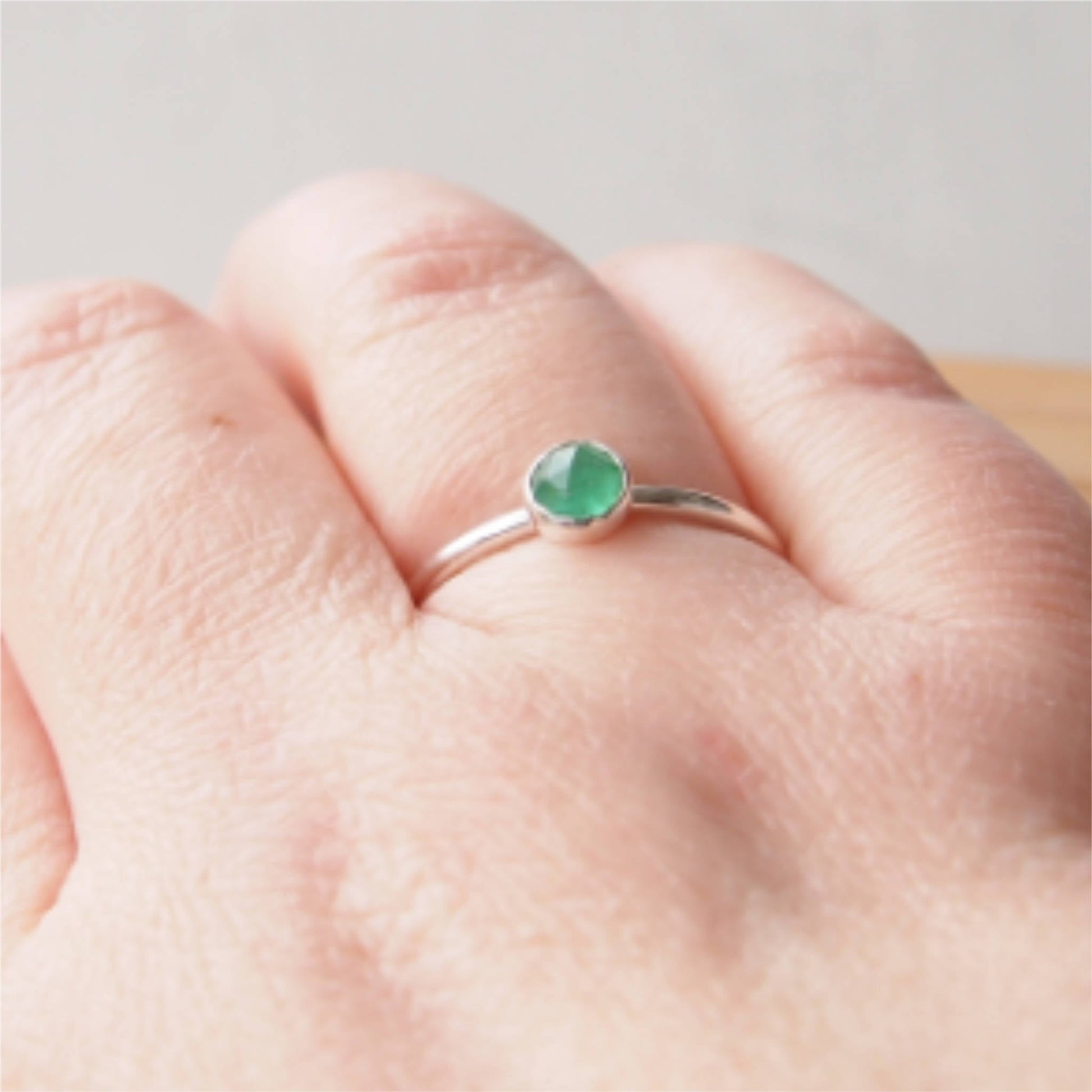 Simple Silver and Emerald ring with a round 5mm green emerald, May's Birthstone. Handmade by Maram Jewellery in Scotland