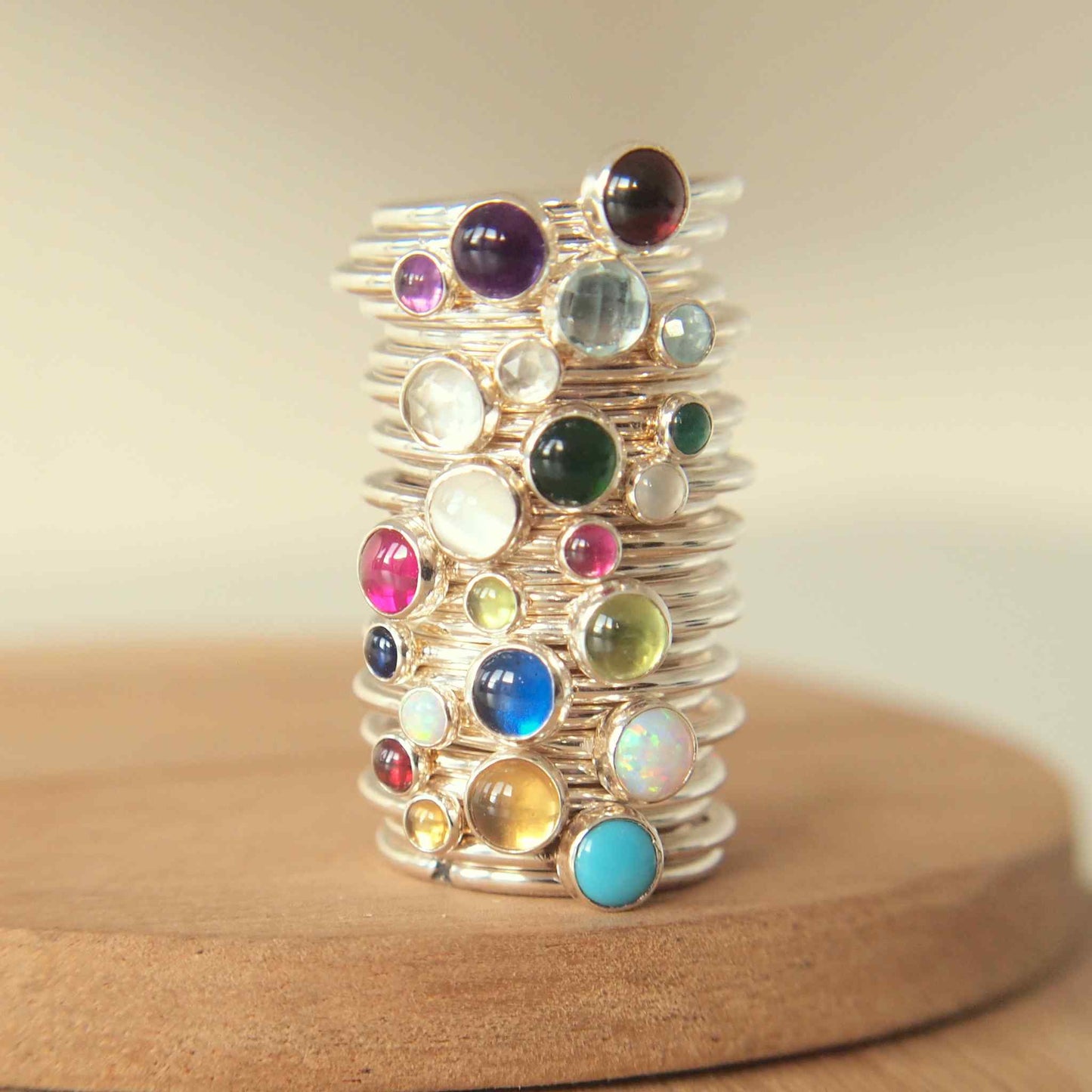 Stack of birthstone rings showing all birthstones in two sizes. Handmade by maram jewellery in Scotland