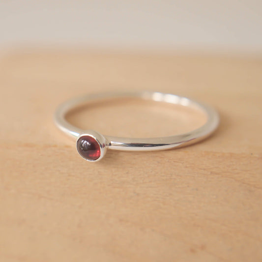 Simple Silver and Garnet ring with a round 3mm deep red Garnet, January Birthstone. Handmade by Maram Jewellery in Scotland