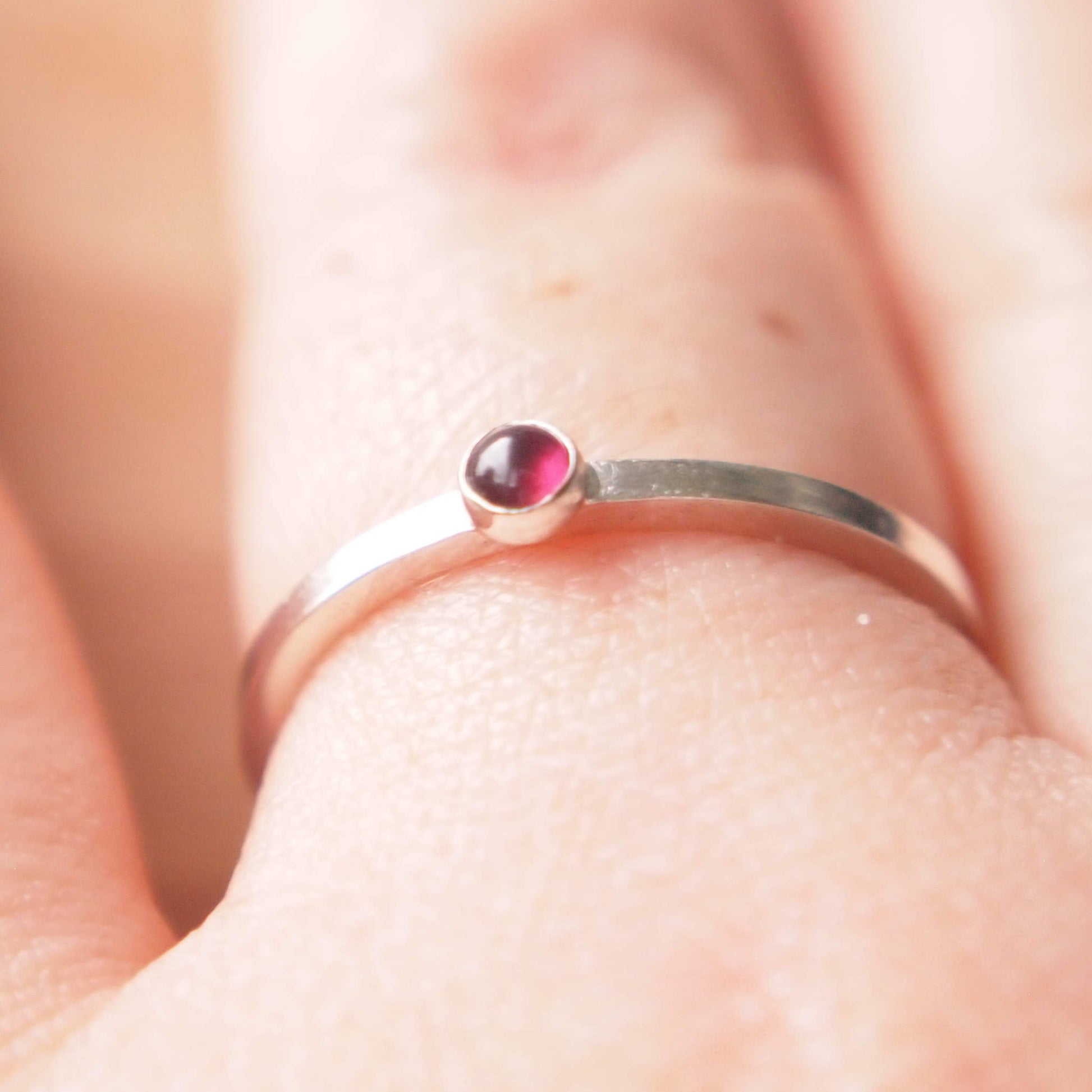 Small Garnet gemstone ring in sterling silver with a square band with a 3mm sized round dark red garnet, which is the birthstone for January. Handmade in Edinburgh by Maram Jewellery