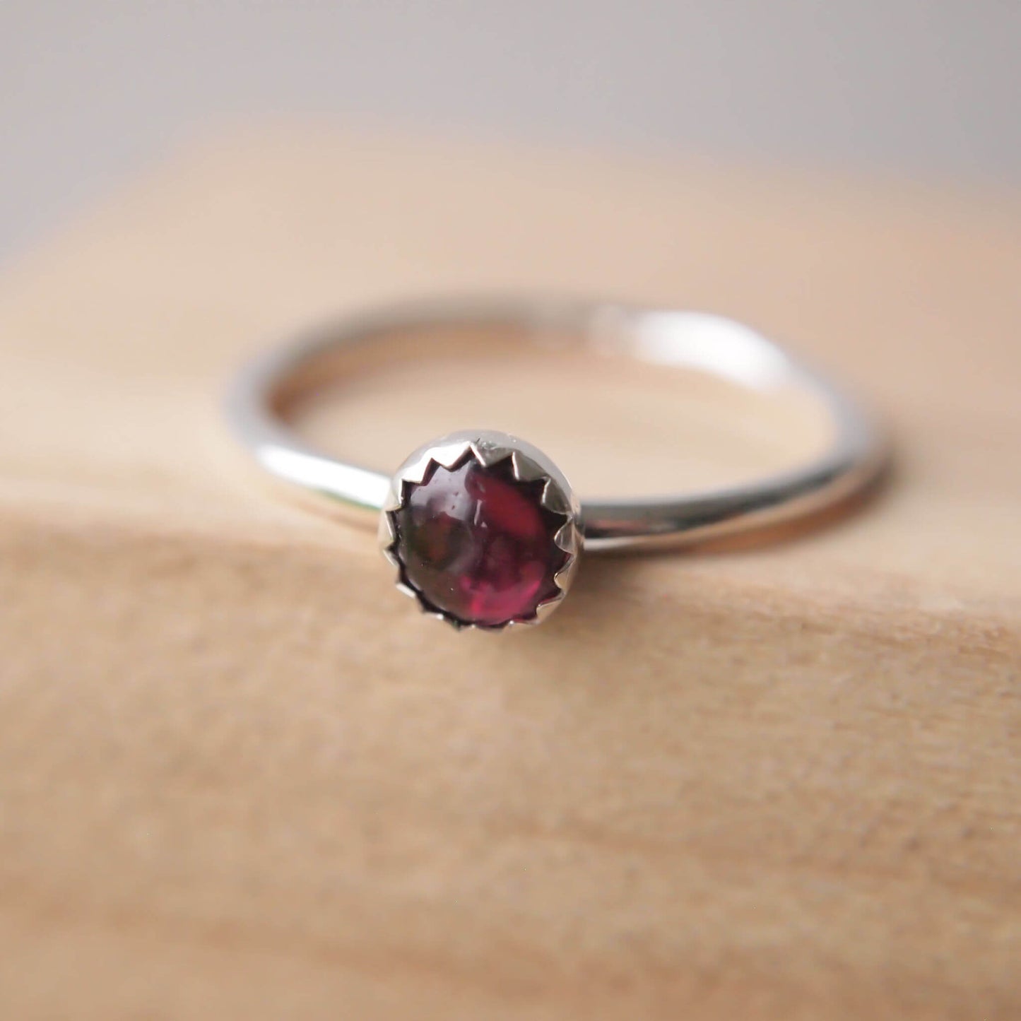 Simple styled silver and dark red gemstone ring with a Garnet round stone on a silver band. The ring is made from a 5mm round cabochon in deep red. Handmade to your choice of ring size by maram jewellery in Scotland