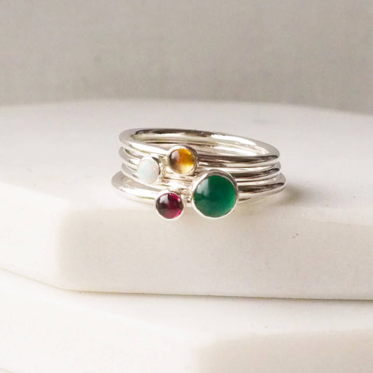 Four rings with the birthstones for May, January, November and October as as a four ring set made by maram jewellery