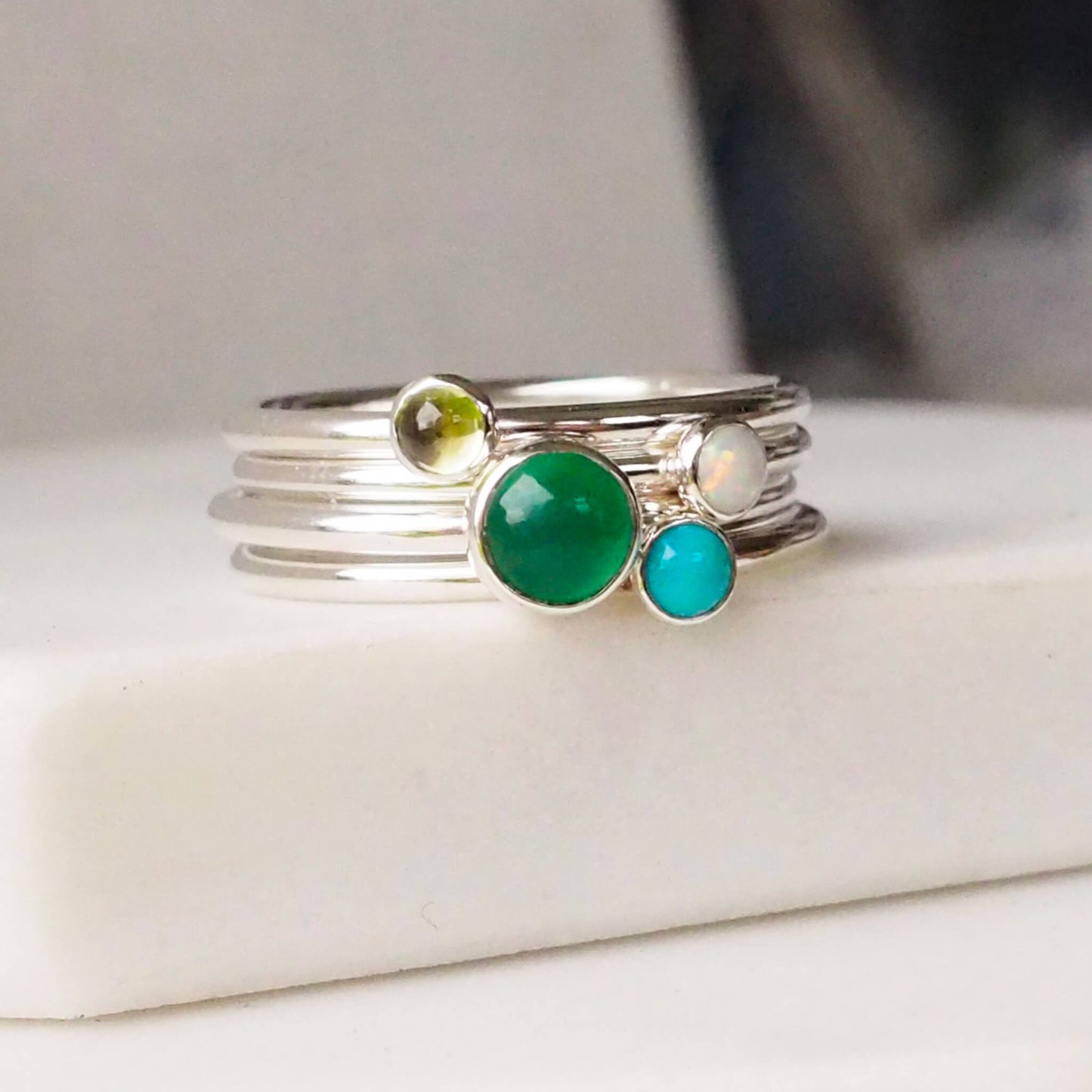 Four rings with the birthstones for May, December, August and October as as a four ring set made by maram jewellery