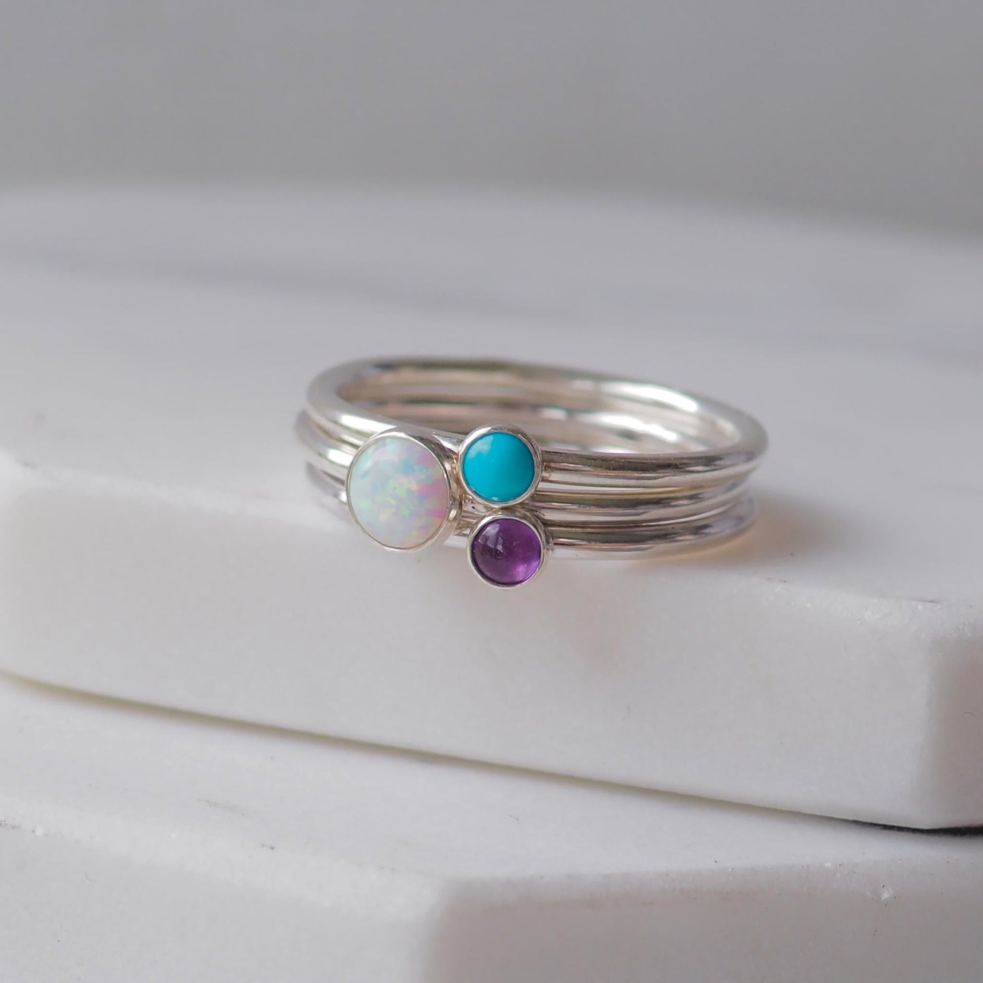 Three silver rings with lal Opal Turquoise and Amethyst gemstones. Birthstones for February, December and October. Handmade to your ring size by maram jewellery in Scotland , UK
