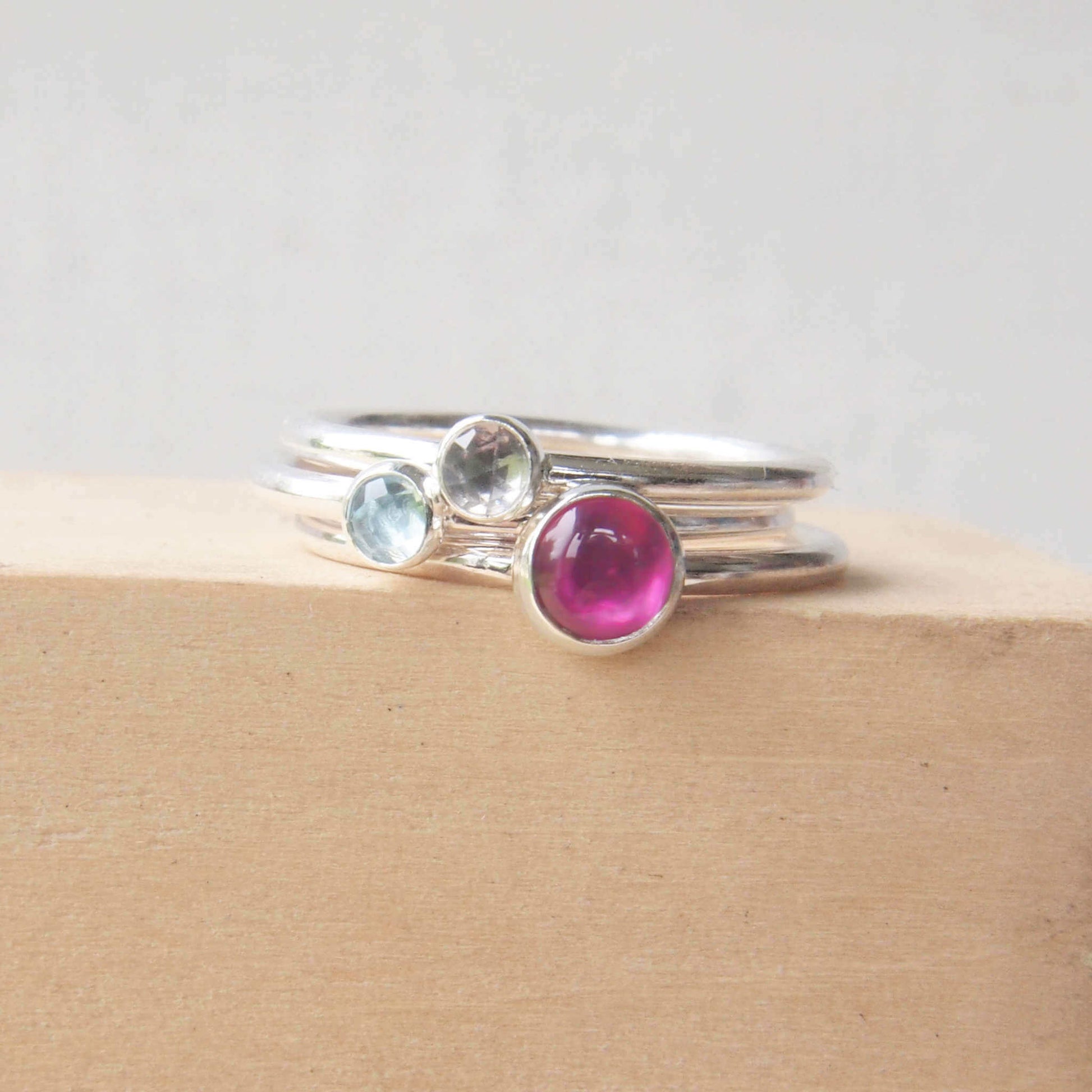 Three ring birthstone ring set made from sterling silver and three gemstones. This set has Lab Ruby, Blue Topaz and White Topaz to mark July, March and April Birthstones.  Handmade in Scotland by Maram Jewellery