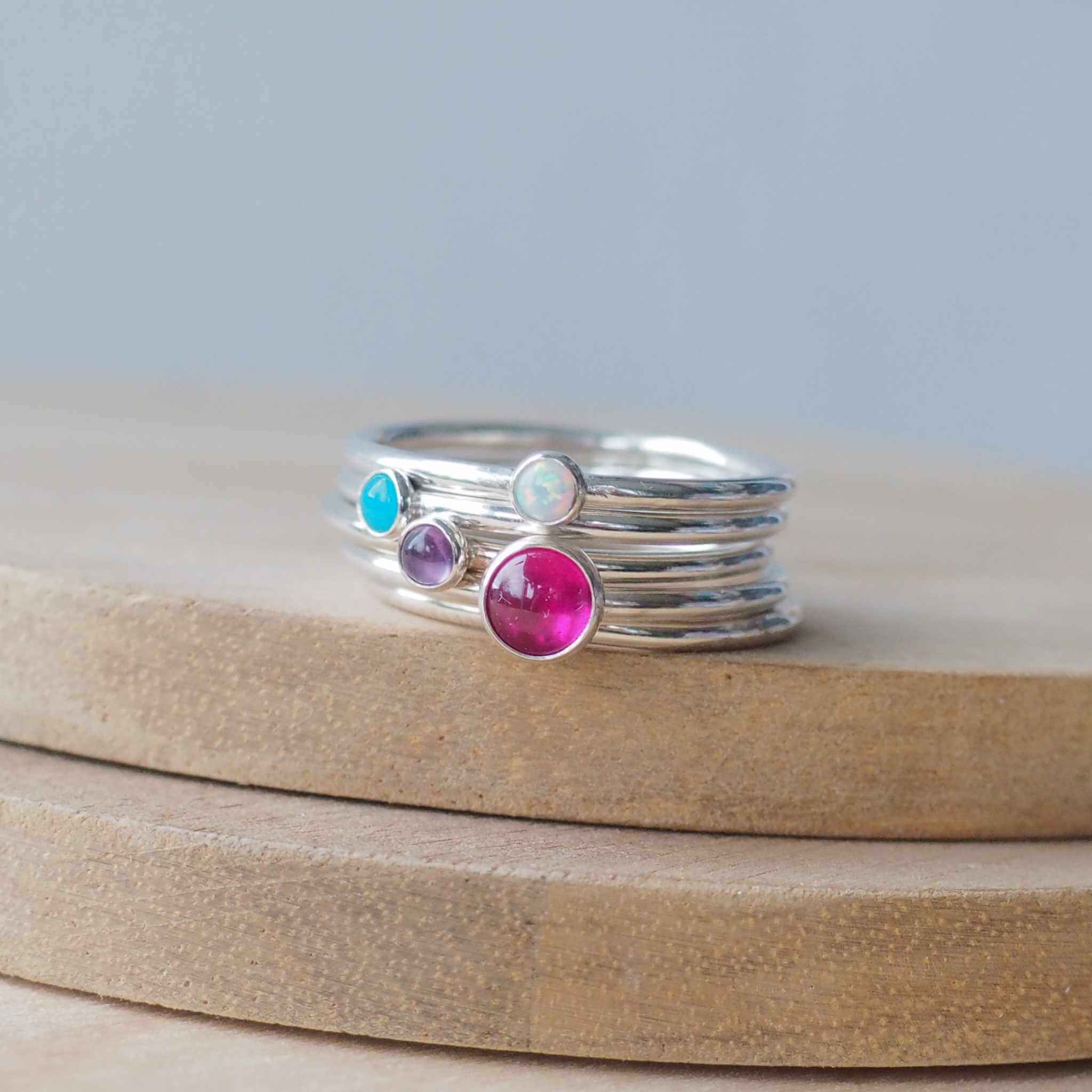 Four Birthstone ring set with July Main Birthstone, Lab Ruby, and any other three birthstones. The stones in the image are a hot pink 5mm lab ruby,and  3mm peridot, Turquoise, and Lab Ruby . Four separate rings all in Sterling Silver, and handmade in Edinburgh by Maram Jewellery