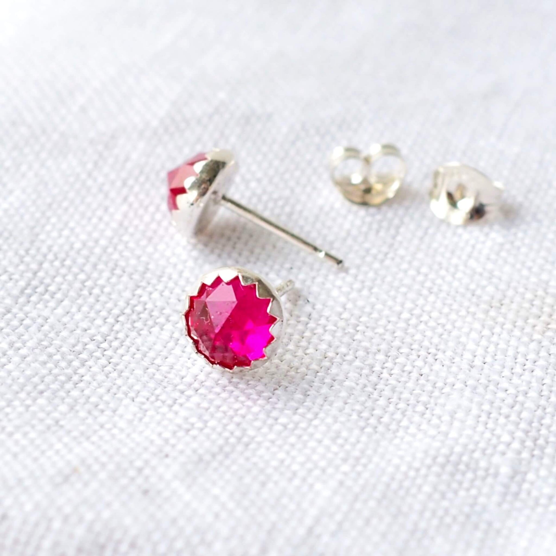 hot pink Gemstone stud earrings with a bright lab ruby artificial gemstone, round and faceted 6m in size. Set onto Sterling Silver settings. Birthstone for July Handmade in Scotland UK by maram jewellery