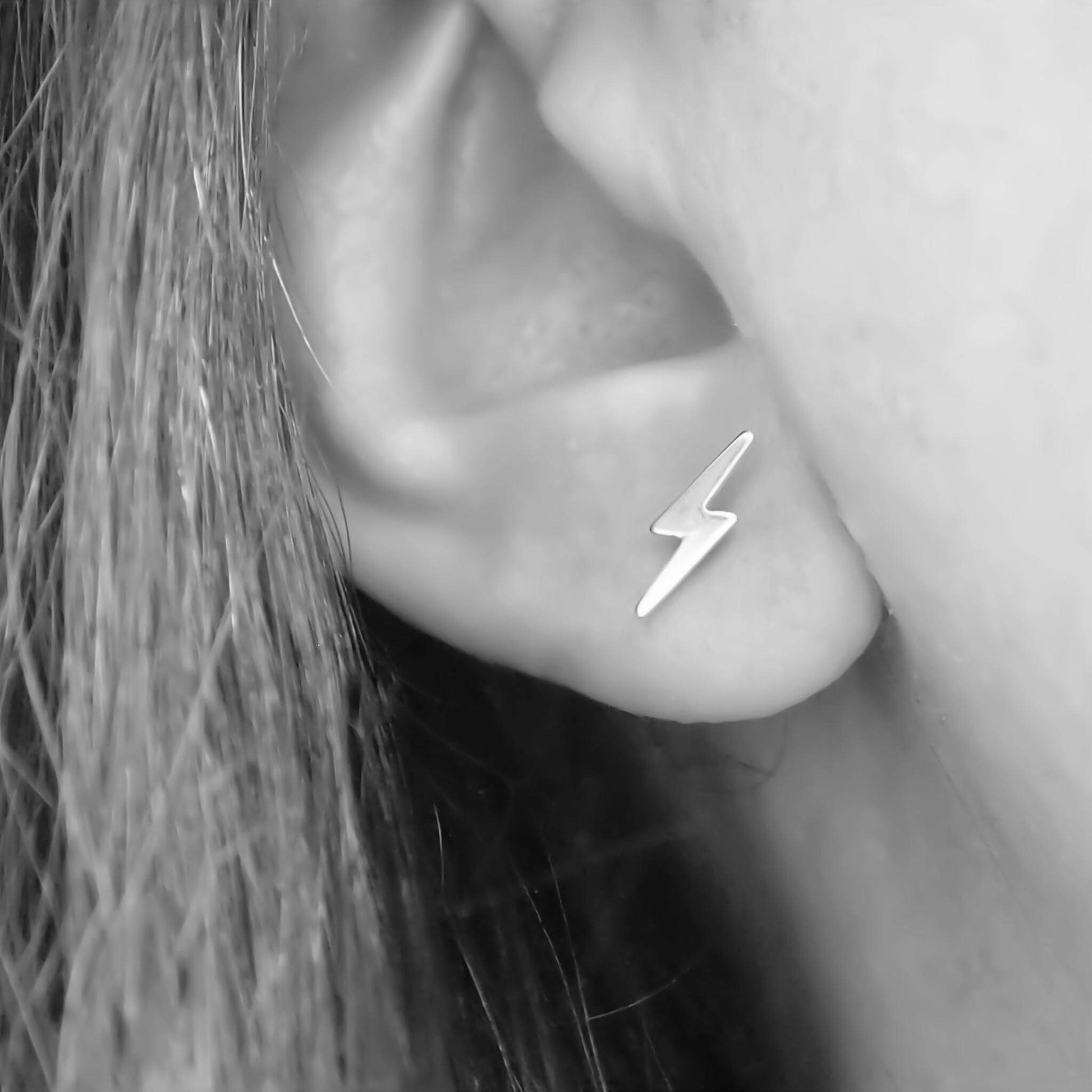 Sterling SIlver lightning bolt earring worn in ear in a black and white image. handmade by maram jewellery in Edinburgh UK
