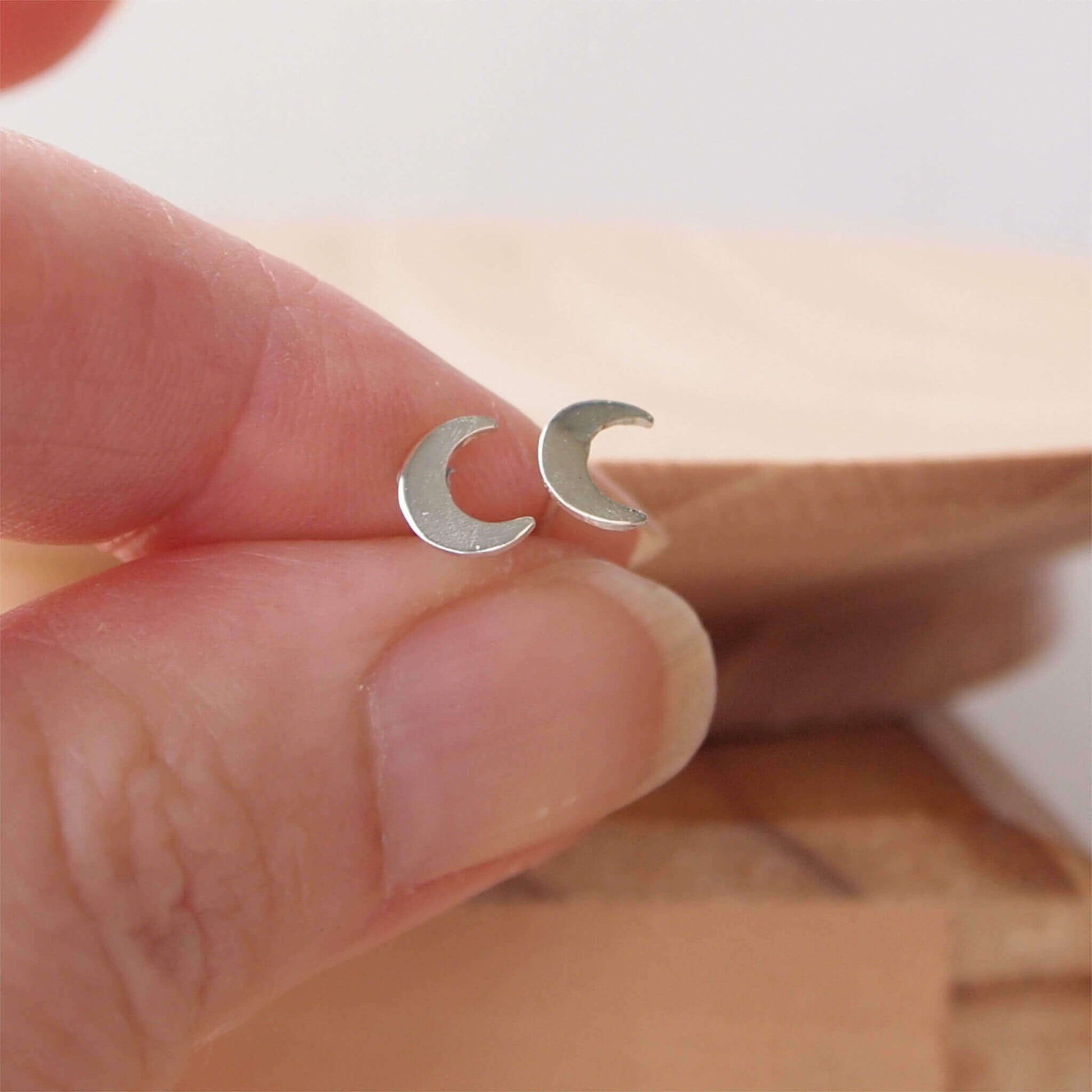 Silver Moon Studs in Sterling Silver measuring a small 11mm in size. Suitable for most ear piercings where a normal stud can be worn and looks great in ears with multiple piercings. Handmade by maram jewellery in Scotland UK