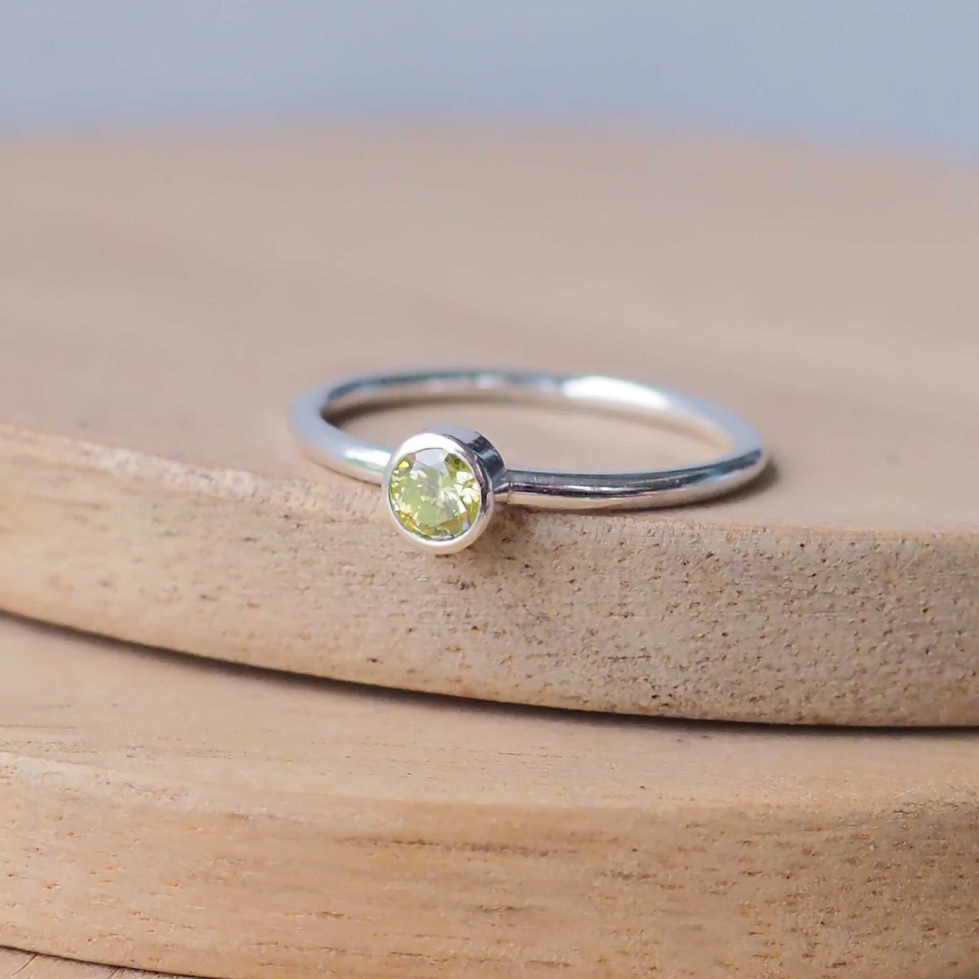 Silver ring with a Mossy light Green Peridot gemstone. The ring is simple in style with no embellishment , with a round wire band 1.5mm thick with a simple Peridot 4mm round cubic zirconia stone set in an enclosed silver setting. Peridot is birthstone for August. The ring is Sterling Silver and made to your ring size. Handmade in Scotland by Maram Jewellery