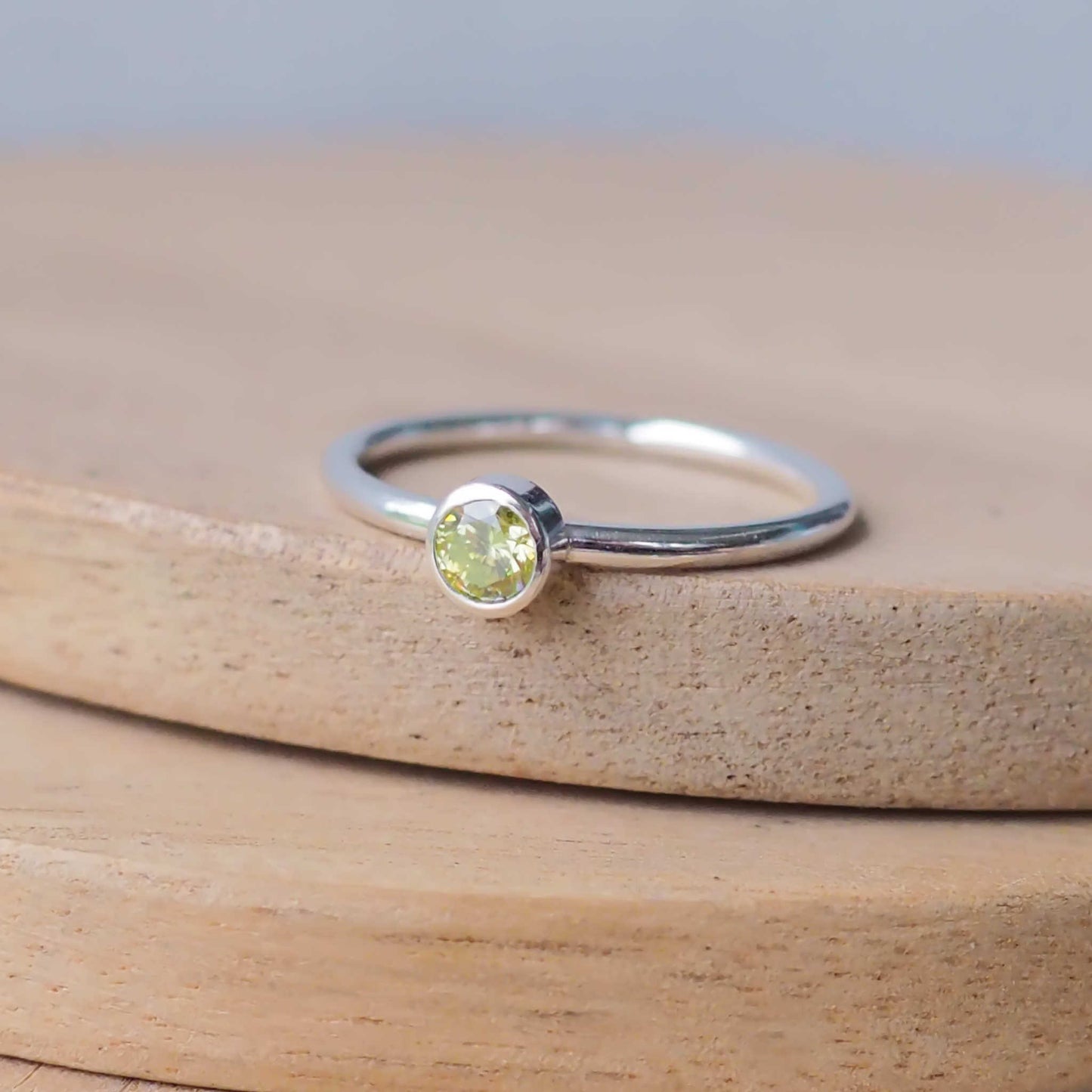 Silver ring with a Mossy light Green Peridot gemstone. The ring is simple in style with no embellishment , with a round wire band 1.5mm thick with a simple Peridot 4mm round cubic zirconia stone set in an enclosed silver setting. Peridot is birthstone for August. The ring is Sterling Silver and made to your ring size. Handmade in Scotland by Maram Jewellery