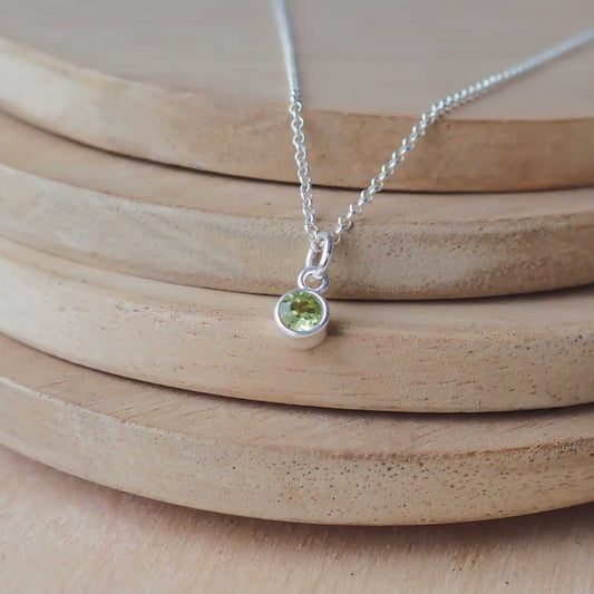 Petite Sterling Silver and Cubic Zirconia Peridot Green necklace with August Birthstone. A small 4mm faceted round clear pale green gemstone with a simple silver setting on a trace style chain. Handmade in Scotland by Maram Jewellery