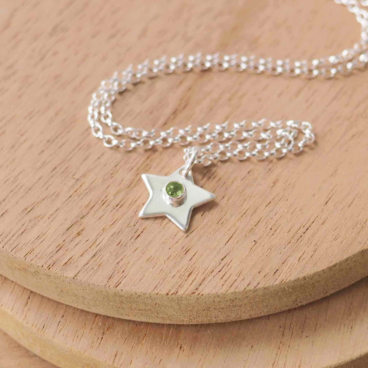 Simple silver star pendant with August Birthstone Peridot which is a green gemstone. The pendant is made from Sterling Silver and is handmade by maram jewellery in Scotland UK
