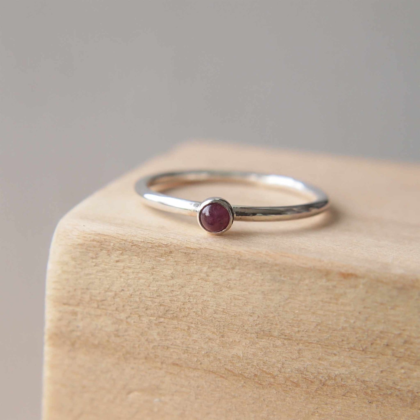 Ruby and Sterling Silver Birthstone RIng for July. The ring is simple in style on a plain fully round band with a small round Ruby in the centre. The ring is handmade to your size by maram jewellery in Scotland