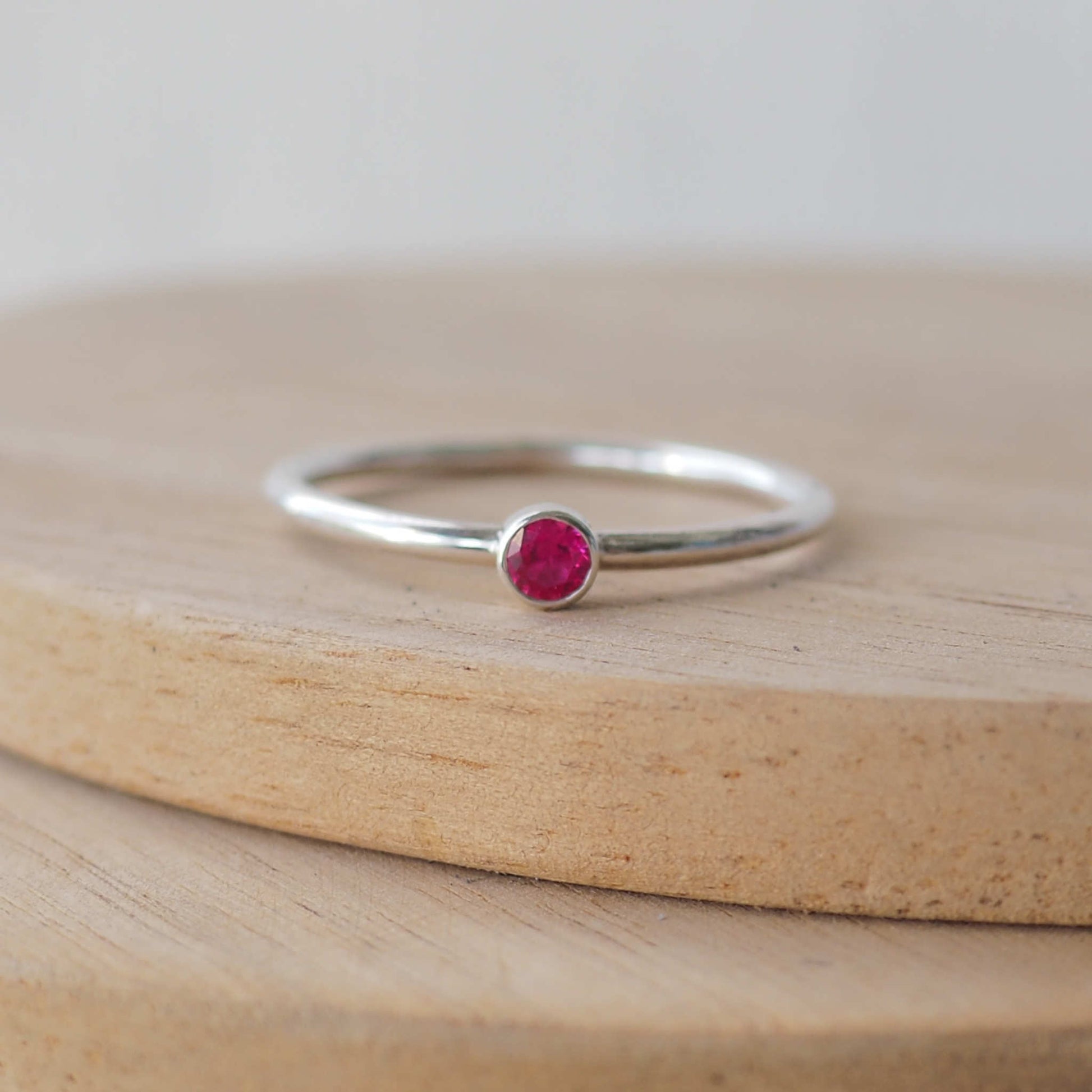 Three Silver rings, each set simply with a single cubic zirconia round 3mm gemstone  in Pink, light green and blue. Birthstones for July,August and September. The rings are Sterling Silver and made to your ring size. Handmade in Scotland by Maram Jewellery