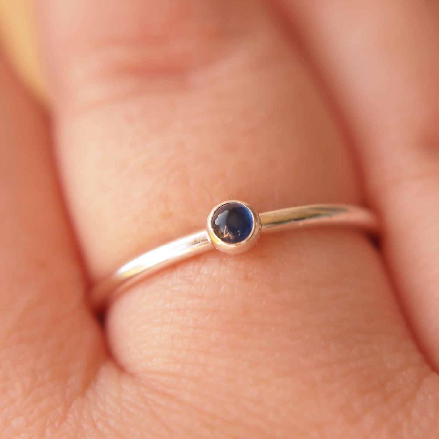Simple Sapphire gemstone ring in sterling silver with a modern round band with a 3mm sized round Blue Sapphire Cabochon. Handmade in Edinburgh by Maram Jewellery