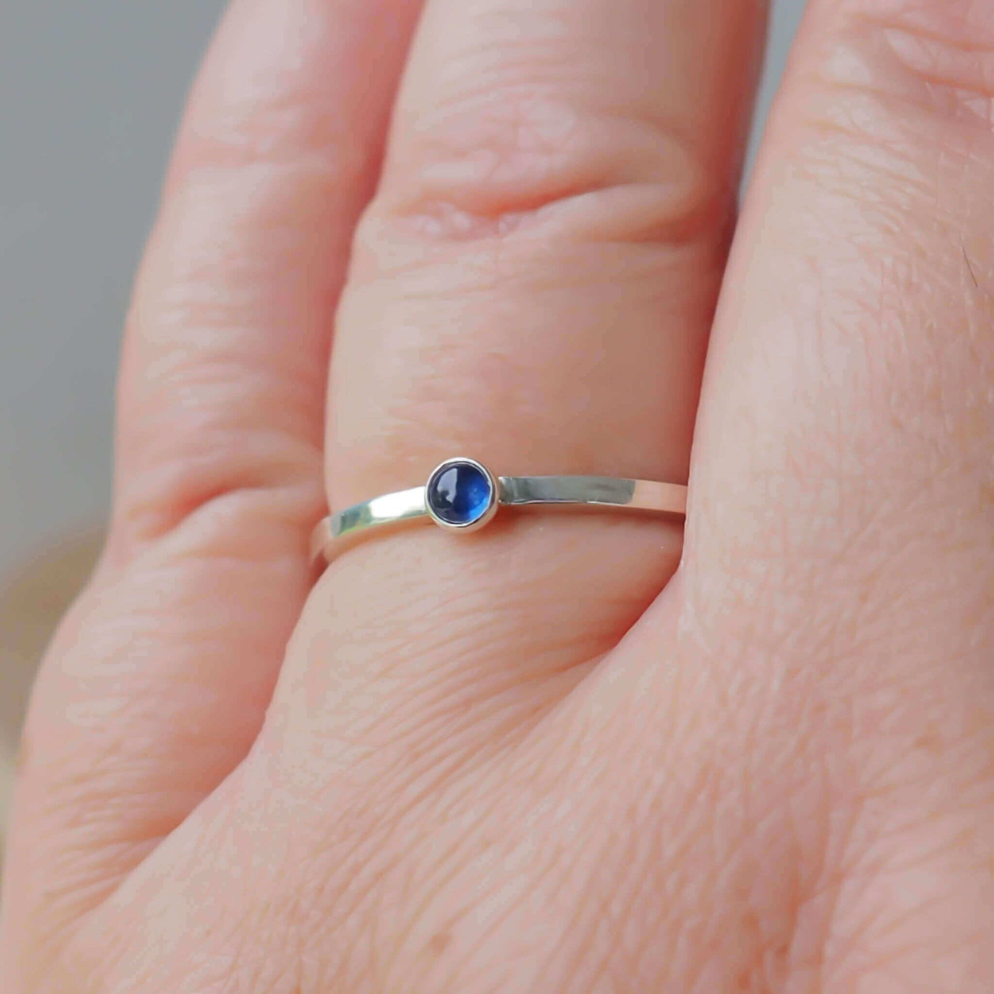 Simple Sapphire gemstone ring in sterling silver with a modern square band with a 3mm sized round Blue Sapphire Cabochon. Handmade in Edinburgh by Maram Jewellery