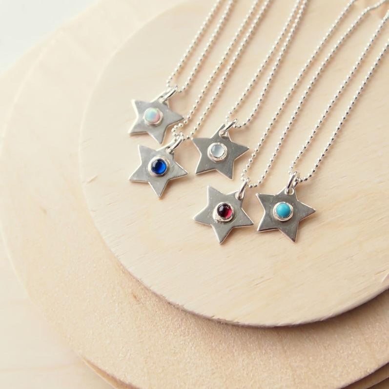 Silver star pendants with different coloured gemstones