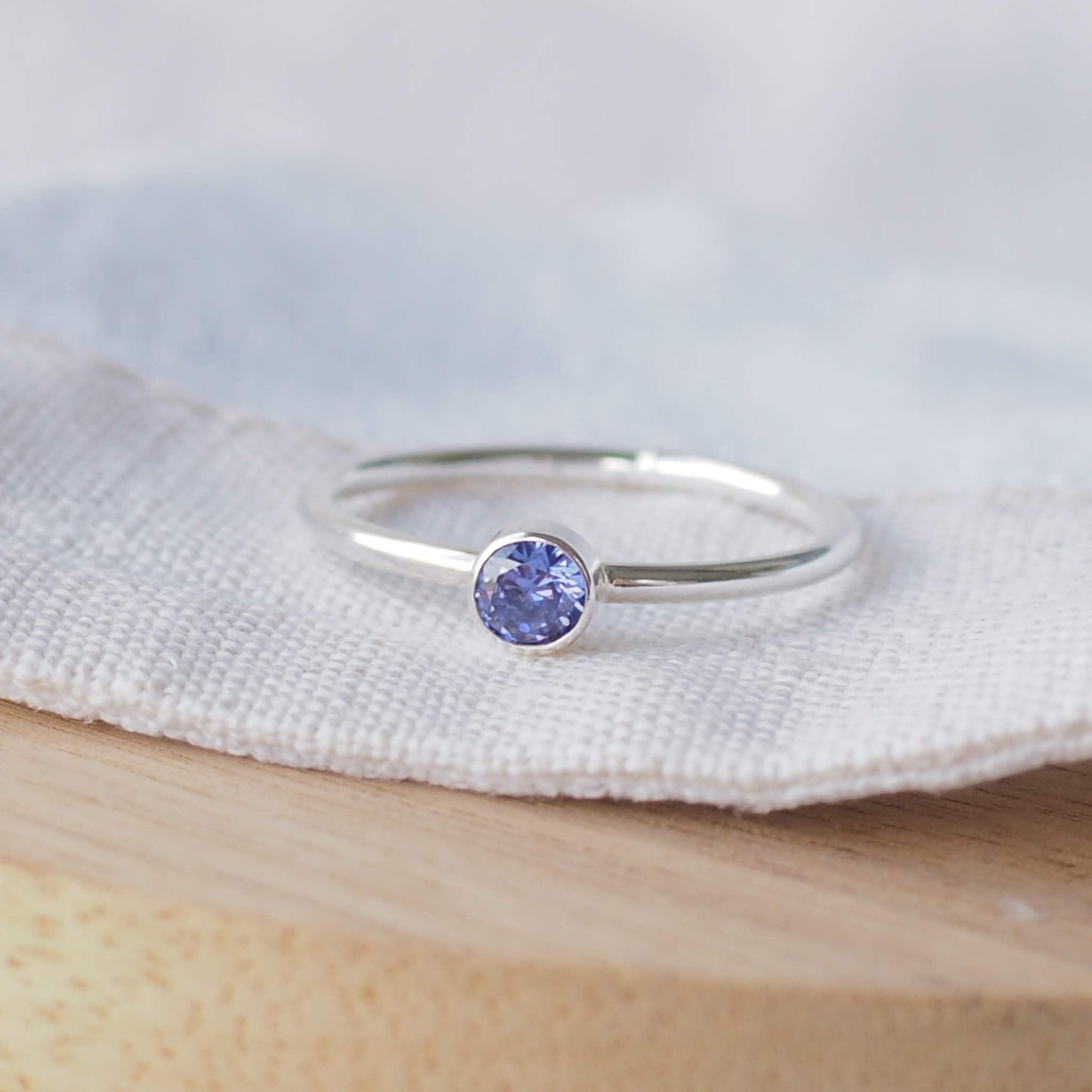 Tanzanite December Birthstone ring made from a Violet Cubic zirconia stone and Sterling Silver. A vibrant round 4mm gemstone set in a minimalist style onto a band of Sterling Silver, and made to order to your ring size. Handmade in Scotland by maram jewellery