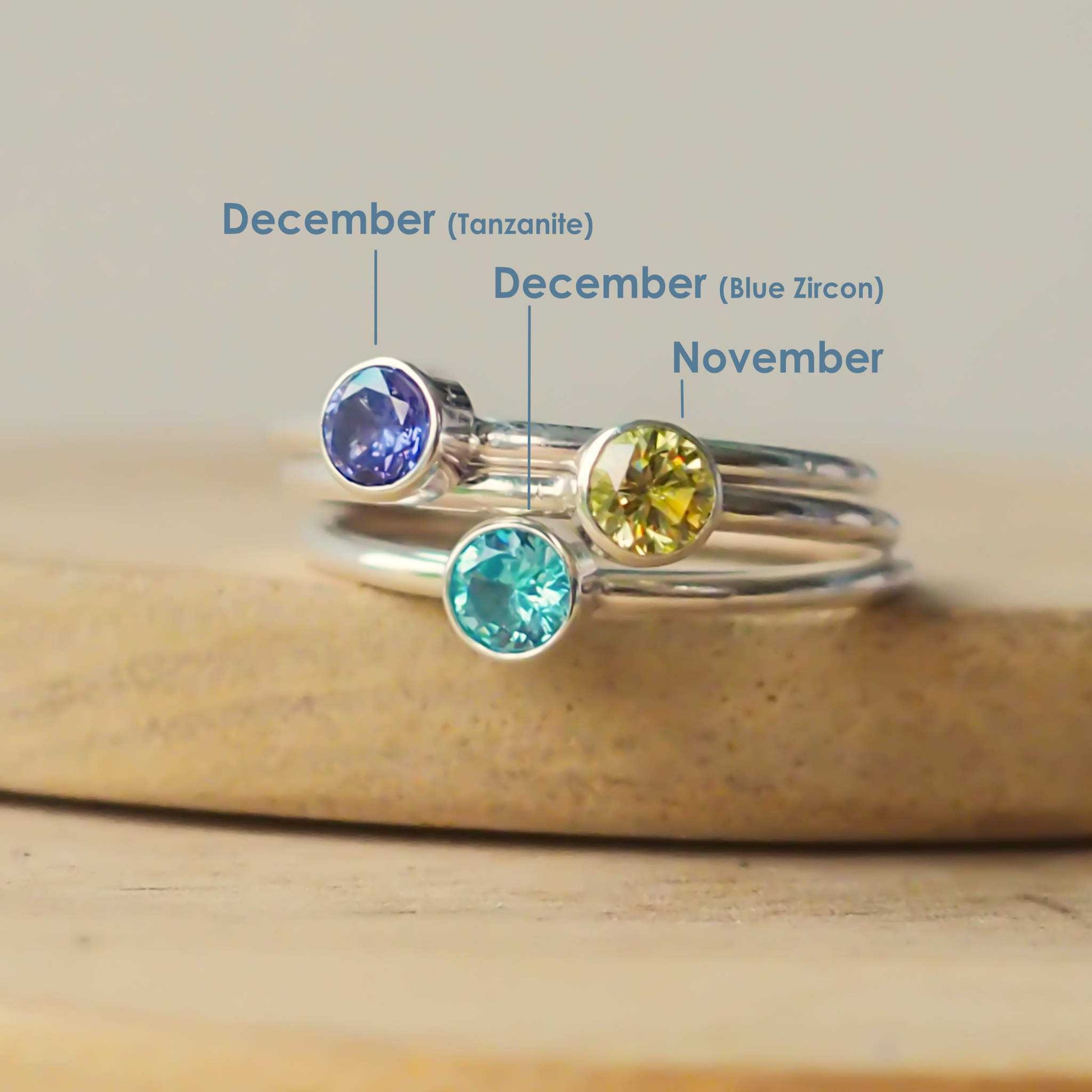 Three rings showing December gem variations - Tanzanite and Blue Zircon, as well as a CItrine for November. These are sterling silver stacking rings made in scotland by maram jewellery